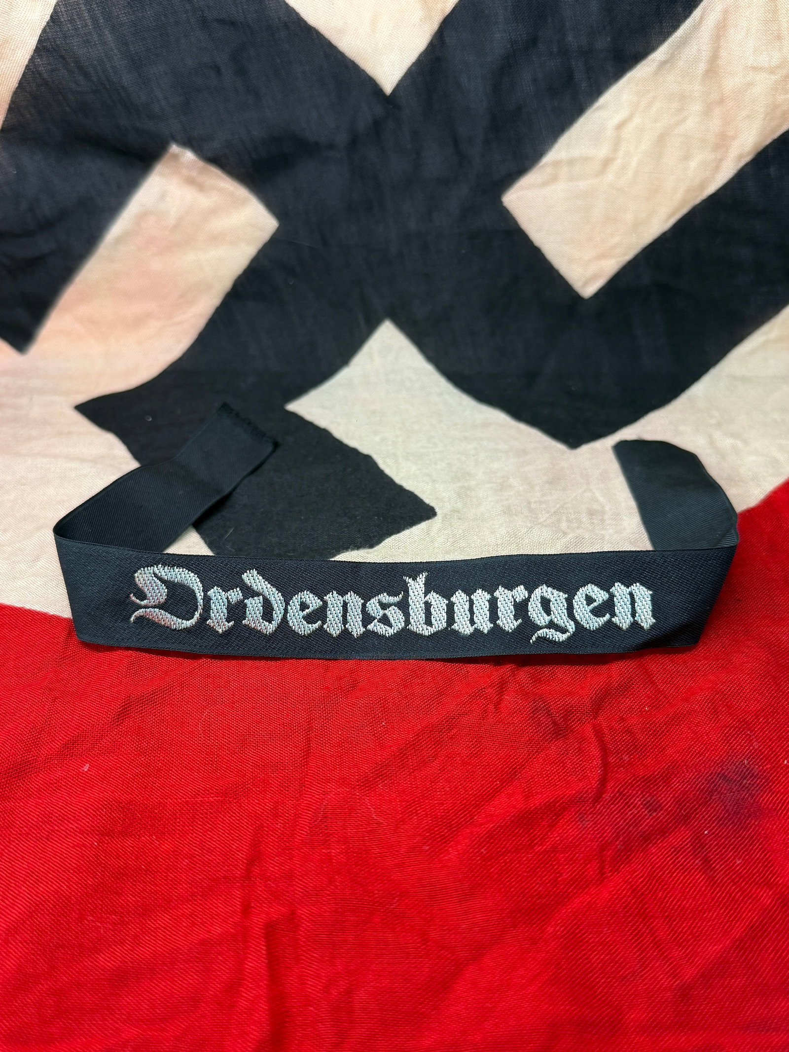 German WWII “Ordensburg?? Cuff Title, c. 1930s–1940s: This cuff title displays the word “Ordensburg,” referring to elite National Socialist training institutions established to prepare future political and ideological leaders. These schools combi
