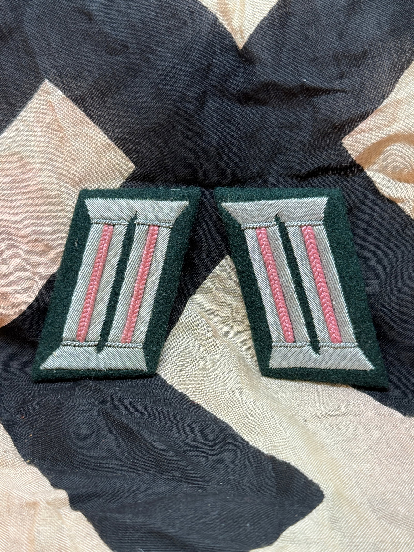 WWII – German Army Collar Tabs (Heer Insignia Pair): This matching pair of collar tabs features embroidered vertical bars framed by colored backing, used on German Army uniforms during World War II. Known as “Litzen,” these insignia were sewn on