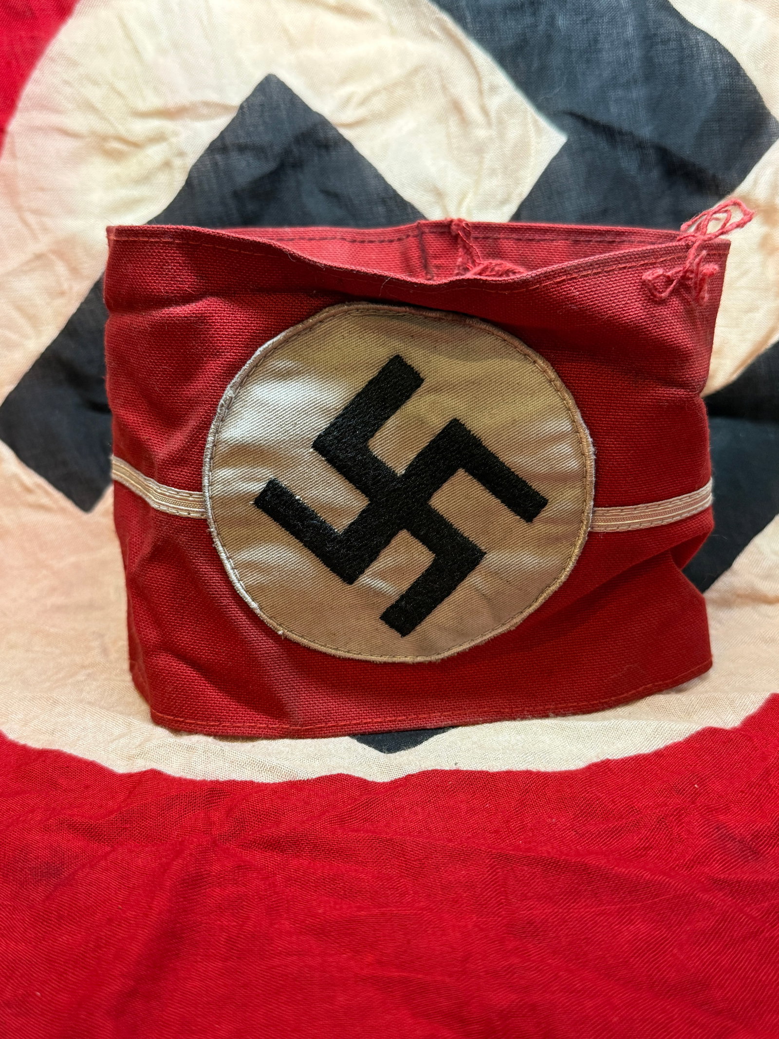 WWII Nazi Party NSDAP Armband: This red armband, bearing the black swastika within a white circle, was worn by members of the National Socialist German Workers’ Party (NSDAP) and affiliated organizations. Typically worn on the up