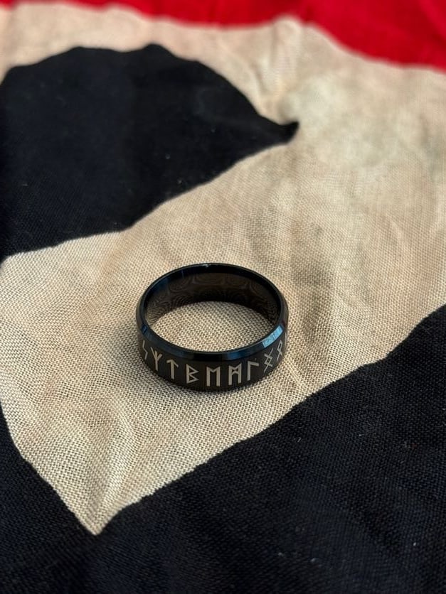 World War II German Runic Motif Ring (Modern Interpretive Piece): This dark-toned ring engraved with stylized runic characters reflects symbolic motifs associated with Germanic heritage that were appropriated during the Nazi period. However, the modern finish, unifo