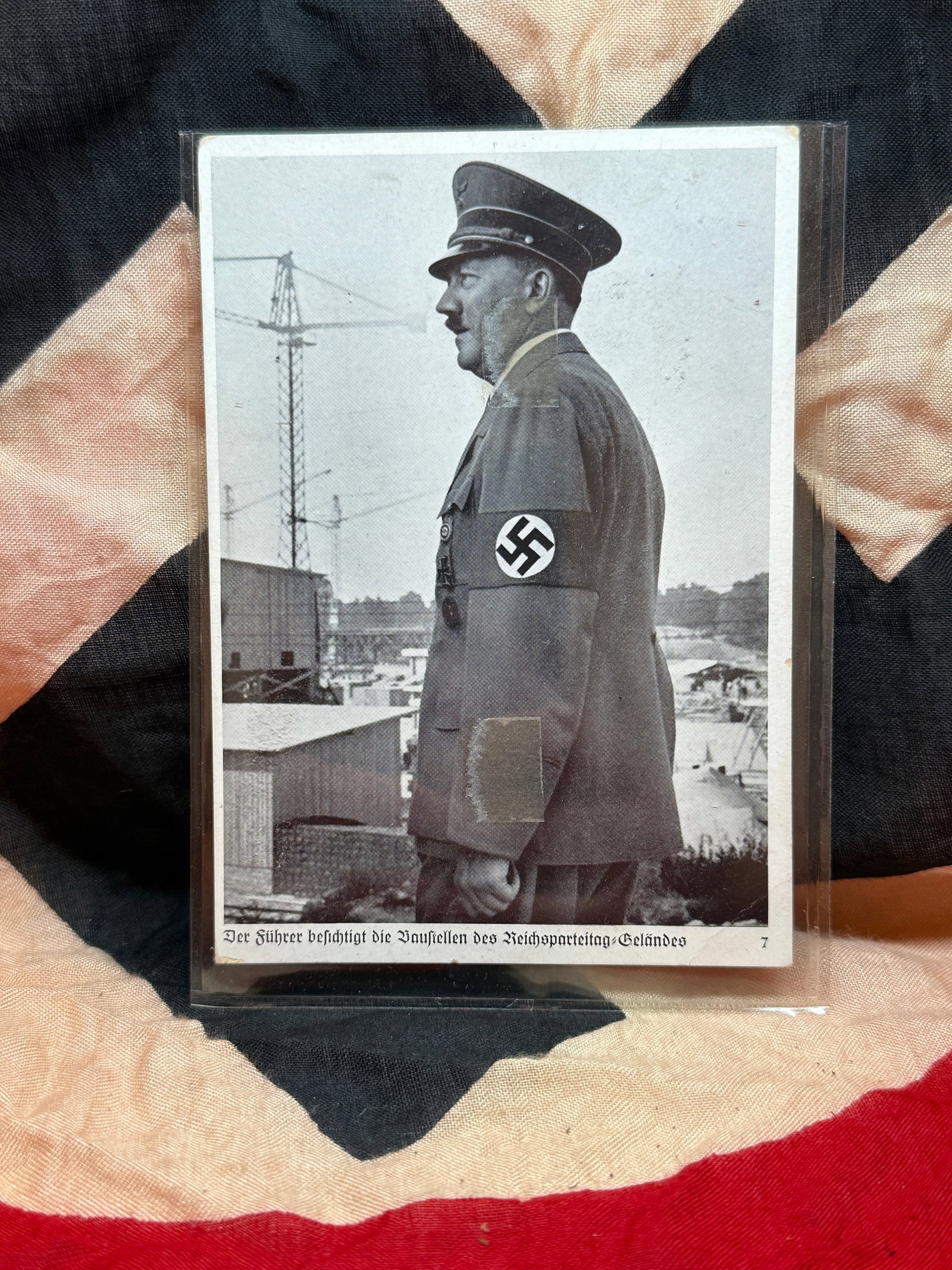 WWII German Propaganda Postcard Featuring Adolf Hitler (Reichsparteitag Grounds): This photographic postcard depicts Adolf Hitler in profile, wearing a political uniform with armband, likely during an inspection of preparations for the Nuremberg Party Rally (Reichsparteitag). The p