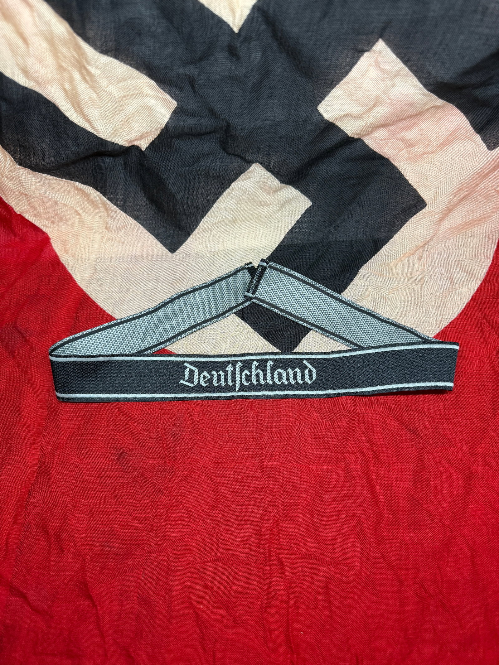 WWII German “Deutschland?? Cuff Title (Uniform Insignia): This woven cuff title bearing the word “Deutschland” is representative of German military or paramilitary uniform adornments used during the WWII era. Constructed from machine-woven fabric wit