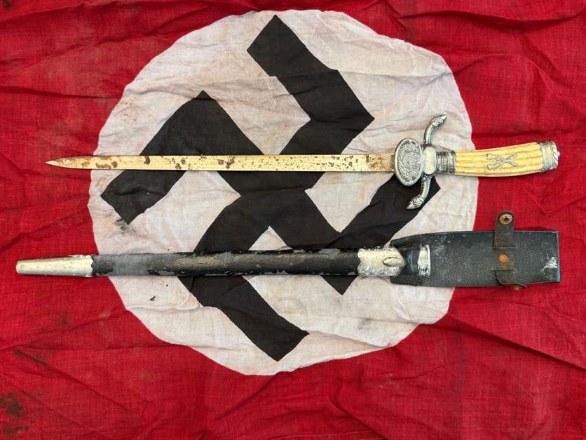 WWII German Forestry or Hunting Association Hirschfänger (Short Sword) with Scabbard: This short sword, often referred to as a Hirschfänger, is associated with German forestry, hunting, or related ceremonial organizations active during the WWII period. The piece features a long, narro