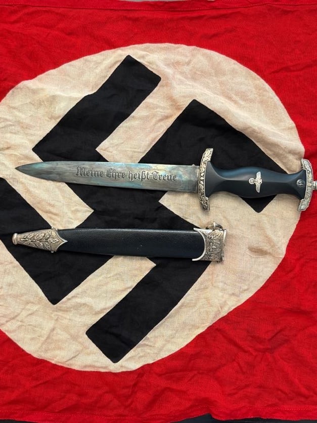WWII German SS Dress Dagger (“Meine Ehre heißt Treue??) with Scabbard: This dagger represents a standard dress weapon associated with the Schutzstaffel (SS) during World War II. The blade is etched with the motto “Meine Ehre heißt Treue” (“My honor is loyalty&