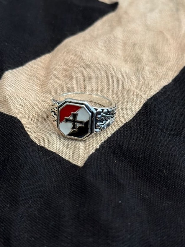 WWII German Patriotic Enamel Signet Ring with Iron Cross Motif (Commemorative Type): This signet-style ring features a multi-colored enamel face incorporating an Iron Cross motif, a symbol widely associated with German military tradition. The decorative shoulders and stamped interior