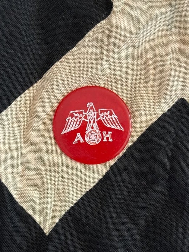 World War II German Labor or Organizational Token (Red Enamel Disk, “1000 RM??): This red circular token bears the inscription “1000 RM” (Reichsmarks) along with German text and an eagle emblem. Such pieces are often associated with organizational, fundraising, or commemor