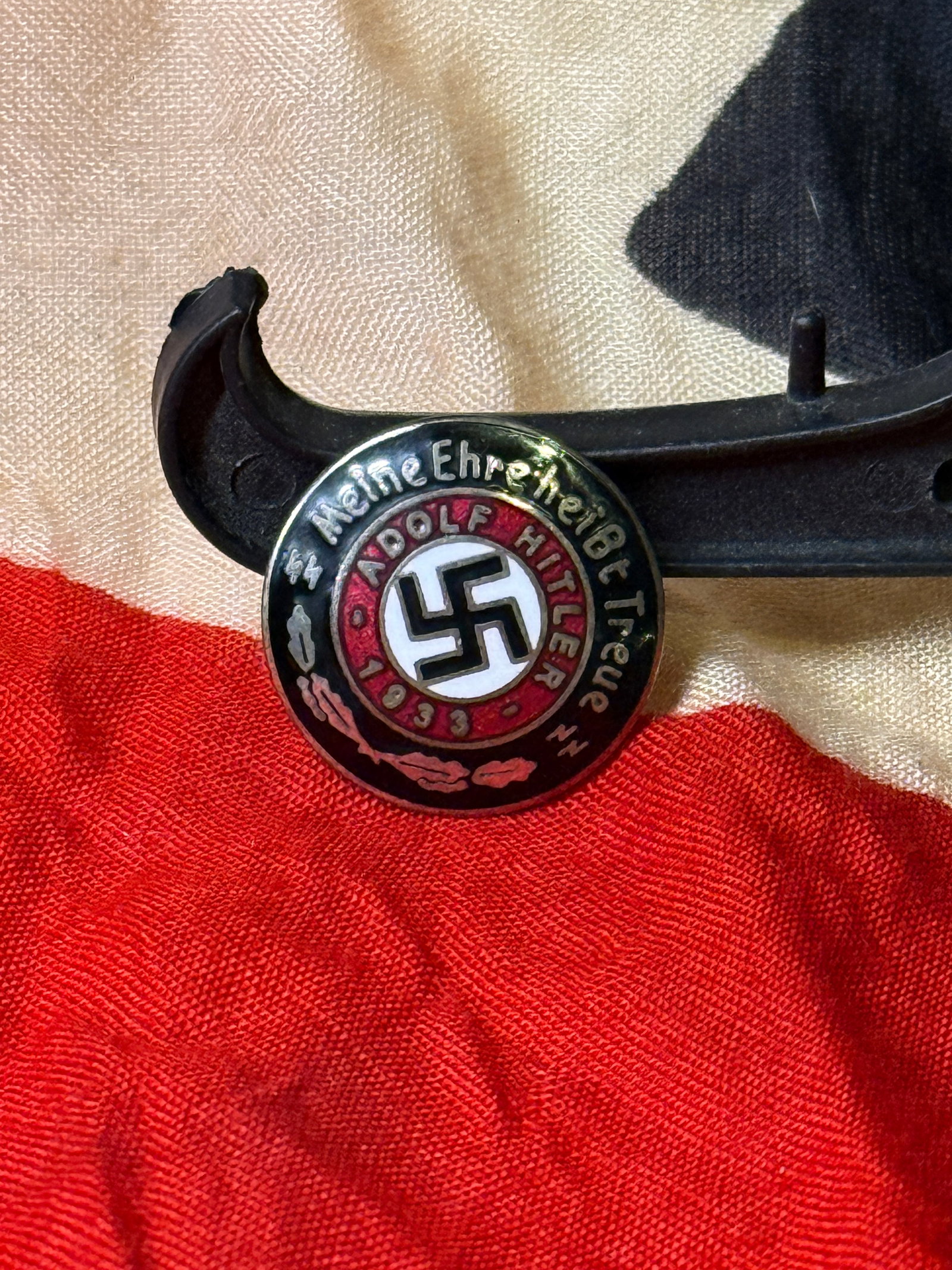 WWII German Adolf Hitler Youth Loyalty Badge (1933 Issue) By Ges. Gesch.: This circular enamel badge bears the inscription “Meine Ehre heißt Treue” (“My honor is loyalty”) surrounding the name Adolf Hitler and the date 1933, marking the rise of the Nazi reg