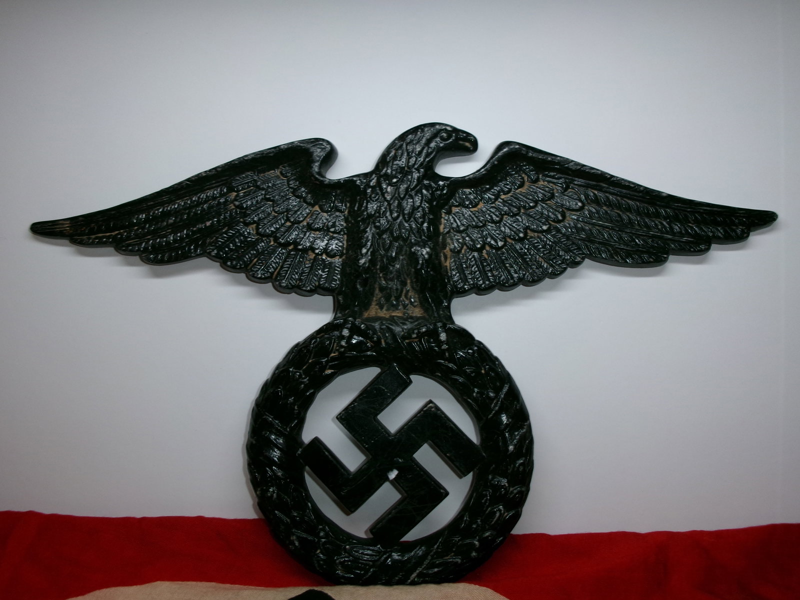WWII German NSDAP-Style Wall Eagle Plaque: This wall-mounted eagle plaque depicts a stylized spread-wing eagle grasping a wreath encircling a swastika—an emblem widely used by the National Socialist German Workers’ Party (NSDAP) and associ