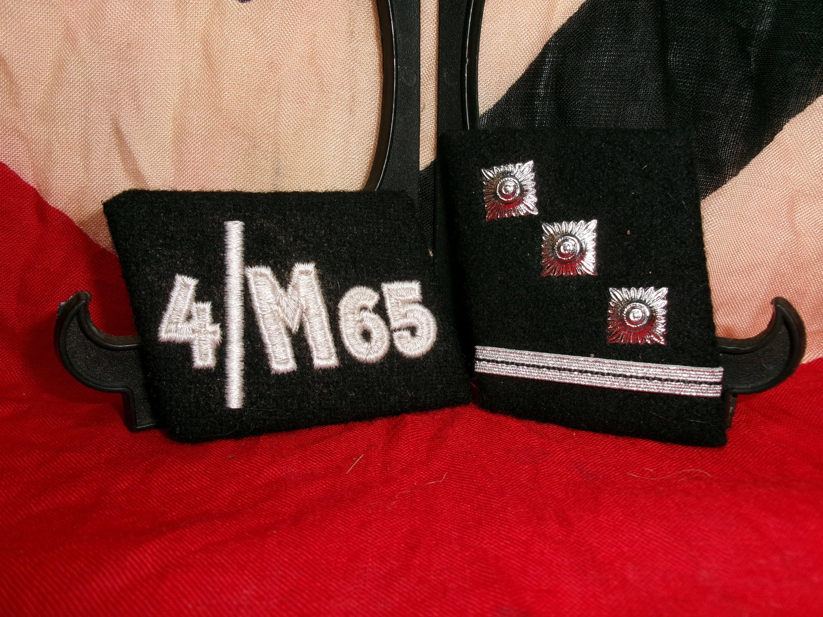 WWII German Waffen-SS Collar Tab Set “4/M65?? with Rank Insignia: This two-piece black cloth collar tab set features embroidered and metal insignia associated with Waffen-SS uniforms from the World War II period. One tab displays the unit-style marking “4/M65&rdqu
