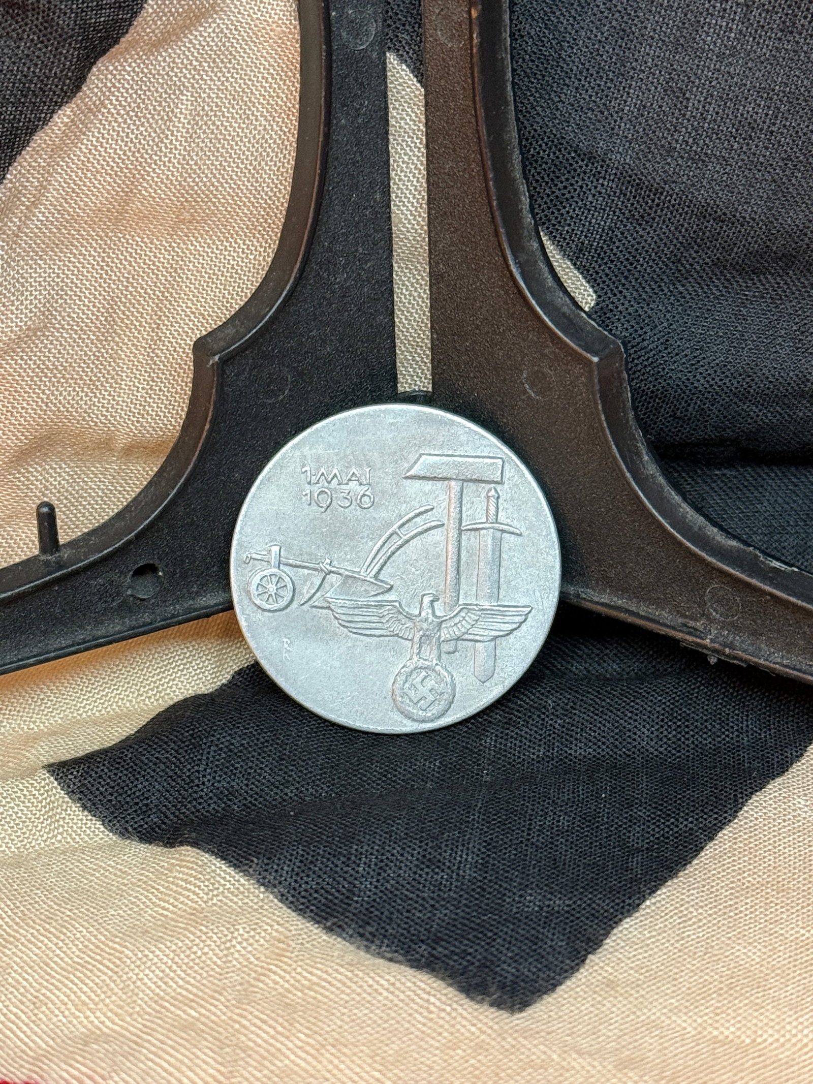 WWII German National Labor Day Badge, “1. Mai 1936?? (Tag der Arbeit Tinnie): A commemorative badge issued for the National Socialist “Day of National Labor” on May 1, 1936. The design incorporates symbolic imagery of labor and industry alongside the German national eag