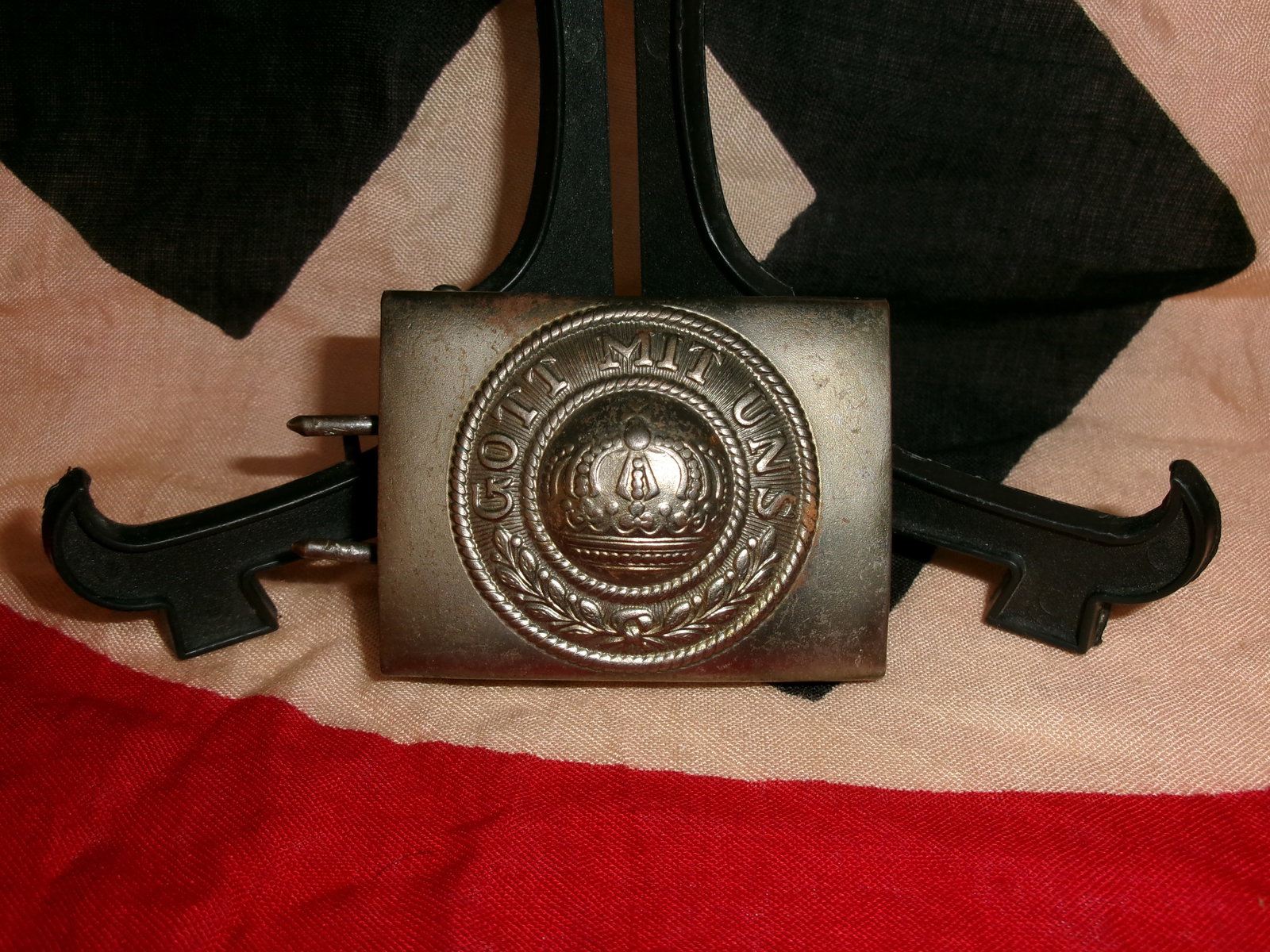 WWI German Imperial Belt Buckle “Gott Mit Uns?? (God With Us): A German Imperial Army belt buckle bearing the motto “Gott Mit Uns” encircling a crowned emblem. This buckle was standard issue for soldiers of the German Empire during the First World War. Th