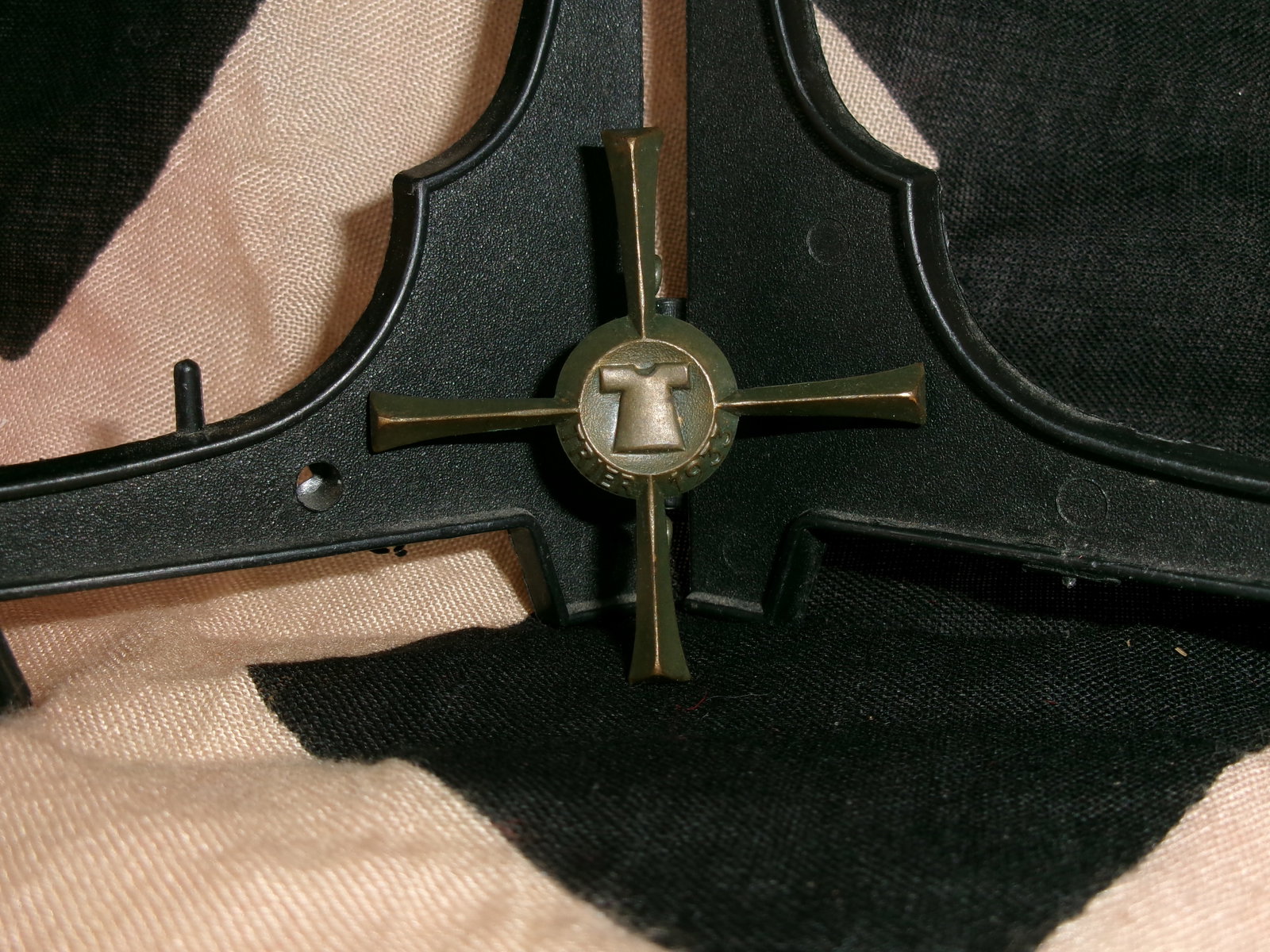 WWII-Era German 1933 Trier Holy Tunic (Heiliger Rock) Tinnie Badge: This stamped metal badge commemorates the 1933 exhibition of the Holy Tunic in Trier, a major religious pilgrimage event that was co-opted for propaganda purposes. The design incorporates a stylized t