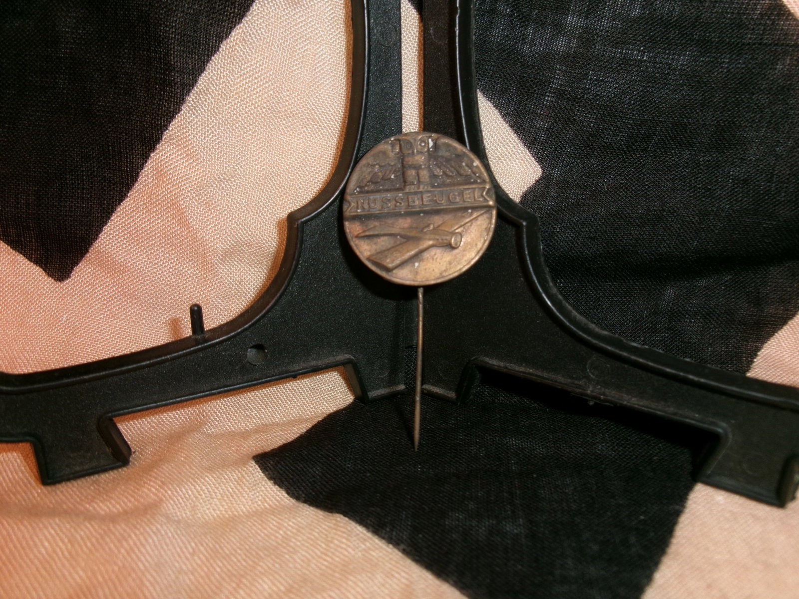 WWII German Shooting Award Stickpin (Schützenabzeichen / “Nussbeugel??): This circular bronze-toned stickpin bears the inscription “Nussbeugel” along with crossed rifles and a stylized eagle motif. Items of this type were associated with shooting competitions and m