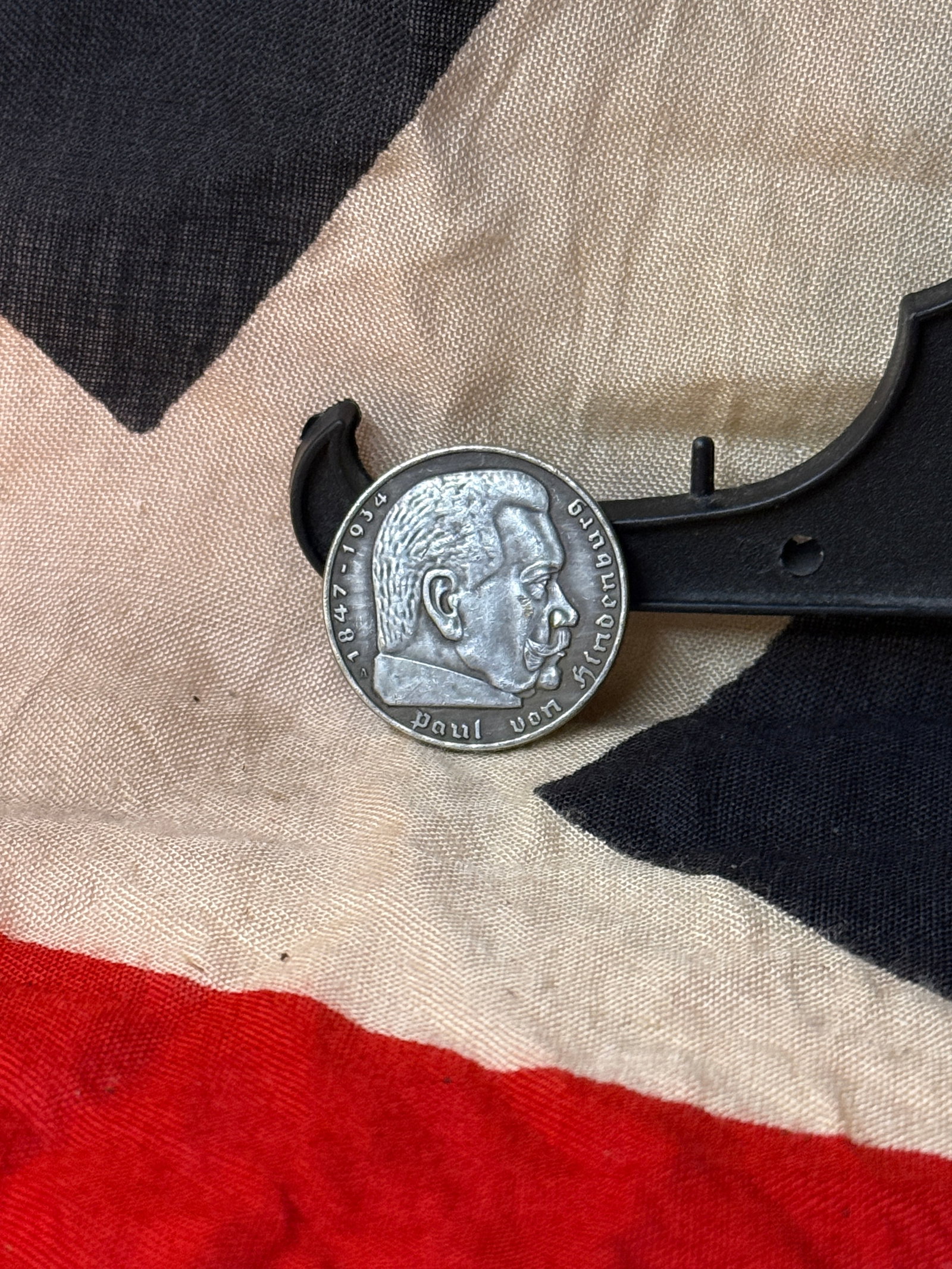 WWII German Commemorative Coin – Paul von Hindenburg / 5 Reichsmark, 1936: This silver-toned coin displays a profile portrait of Paul von Hindenburg, former President of Germany, with dates marking his lifetime. The reverse features the national eagle above a swastika with t