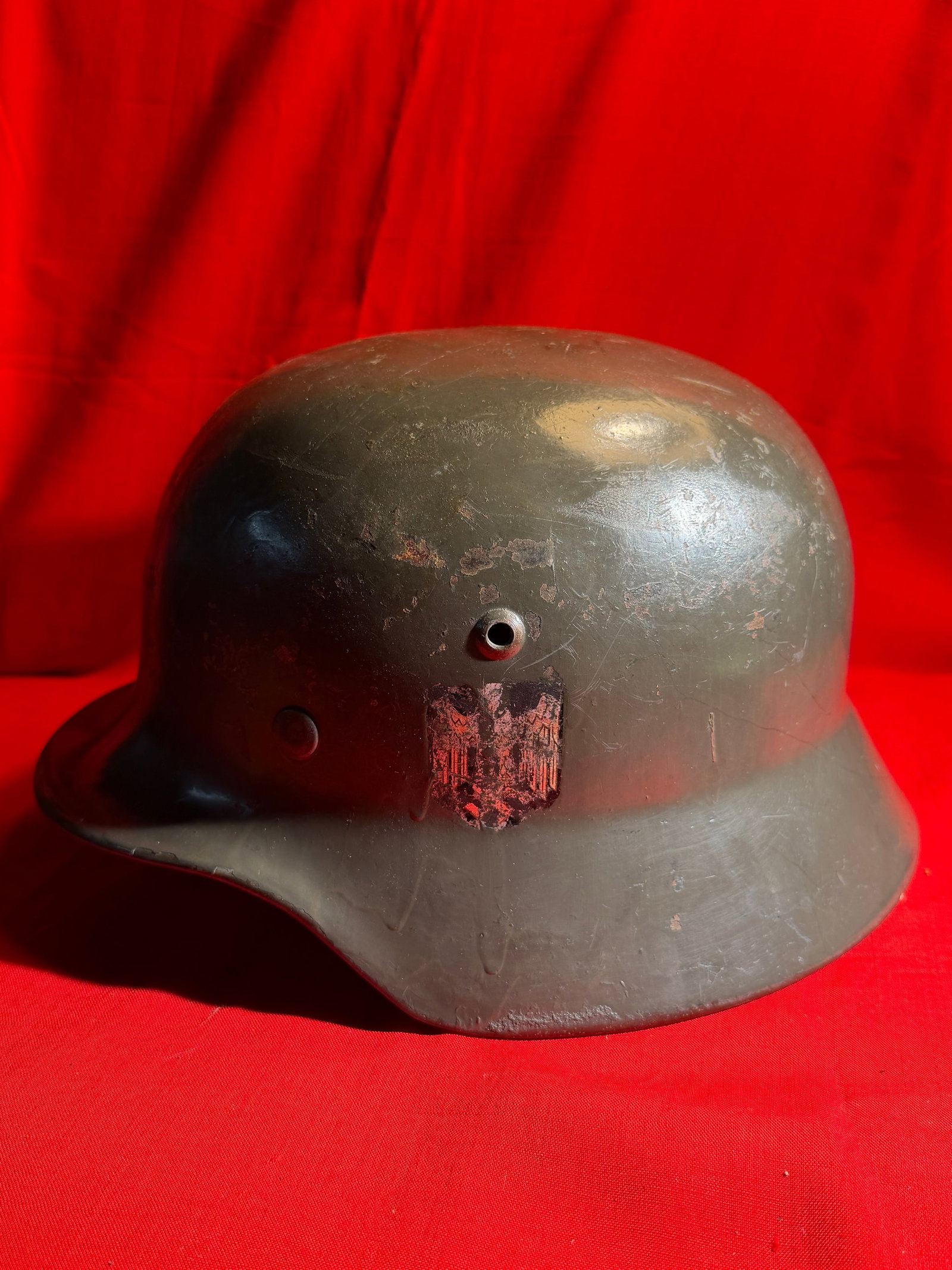 WW2 German Wehrmacht M40 Steel Helmet – Single Decal (Worn Example): World War II German Wehrmacht steel helmet, M40 pattern, featuring the classic flared skirt and rolled edge construction. The helmet retains its original field-gray paint, now heavily worn from age an