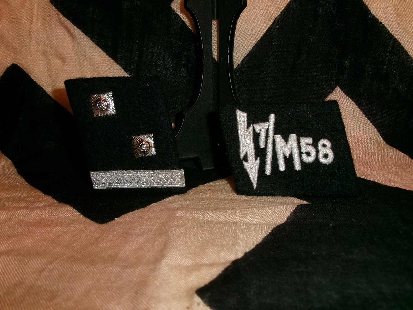 WWII German Waffen-SS Shoulder Boards and Signals Trade Tab (M7/58) With RZM Paper Tag: This matched set of black wool shoulder boards and an embroidered sleeve or specialty tab represents personnel of the Waffen-SS during the Second World War. The shoulder boards display rank pips and m