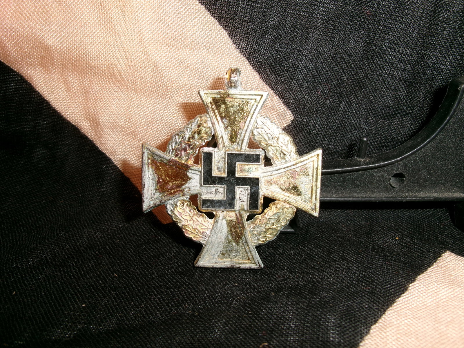 German 25 Year Civil Service Cross – Medal / Pendant: This is a German civil service long-service cross featuring a cross design with central emblem and wreath detail. The piece includes a top loop, indicating it was worn suspended from a ribbon. In our 