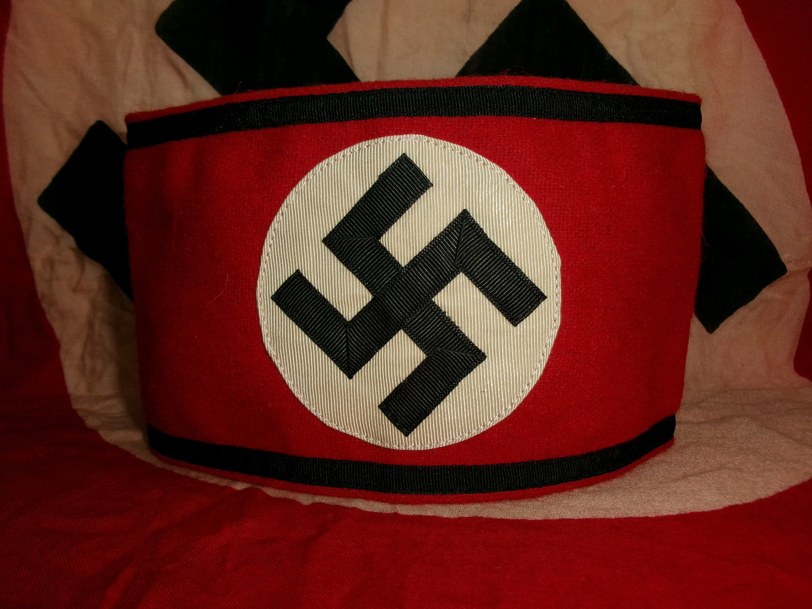 WW2 German Waffen-SS Armband with RZM Cloth Tag: This is a WW2 German Waffen-SS armband, constructed in the classic red wool with a separately applied white roundel and black swastika. The swastika is formed in ribbed cloth, stitched onto the white 