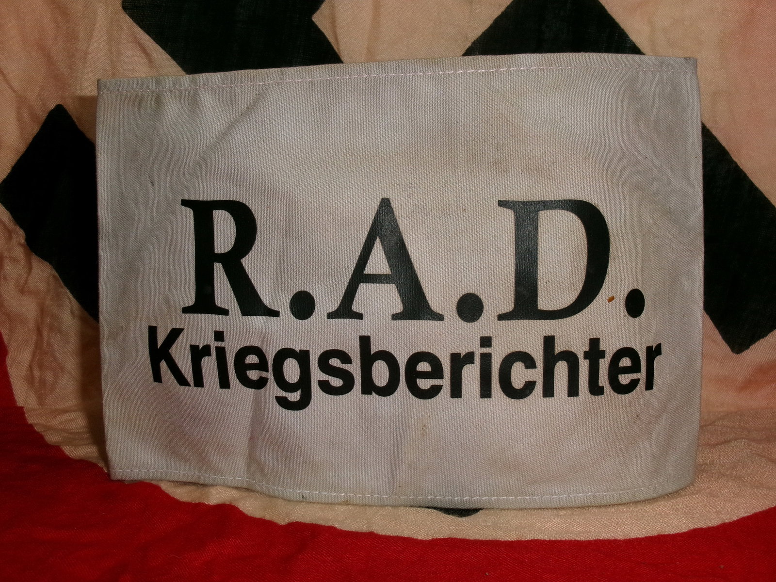 WWII German RAD (Reichsarbeitsdienst) War Correspondent Armband Dated 1943: A white cloth armband printed with “R.A.D. Kriegsberichter” (War Correspondent), indicating affiliation with the Reich Labour Service’s media personnel. The RAD was a paramilitary labor orga