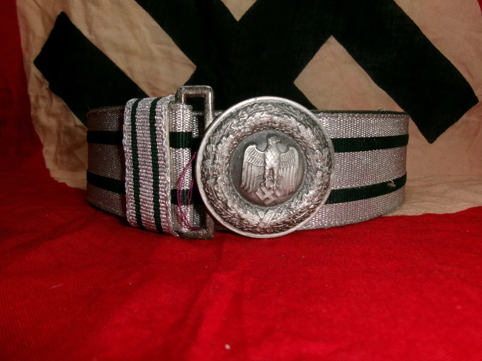 WWII German Wehrmacht Heer Officer’s Brocade Belt with Buckle: A formal German Army (Heer) officer’s dress belt composed of silver brocade fabric interwoven with green stripes, backed by stitched leather. The circular aluminum buckle features the national eagle