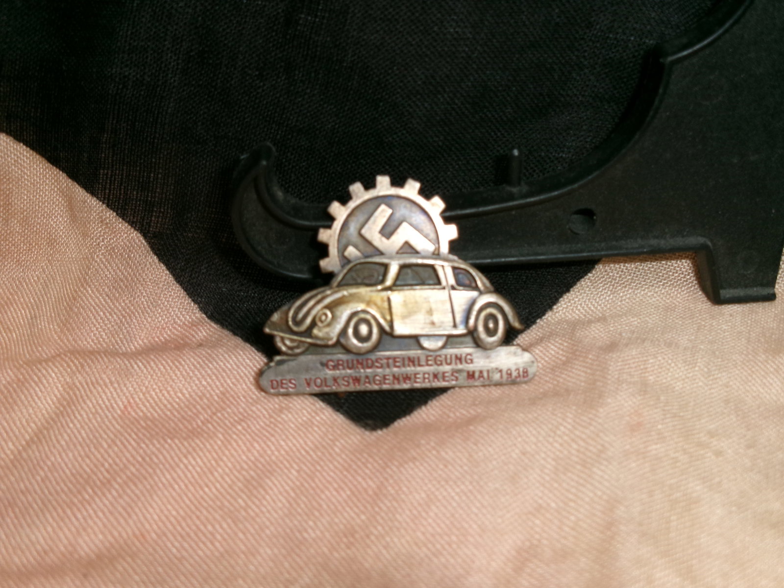 WWII German Volkswagen Factory Foundation Commemorative Pin (May 1938) By Ges. Gesch.: A German commemorative lapel pin marking the foundation ceremony of the Volkswagen factory in May 1938. The design features an early Volkswagen vehicle beneath a gear emblem incorporating the national