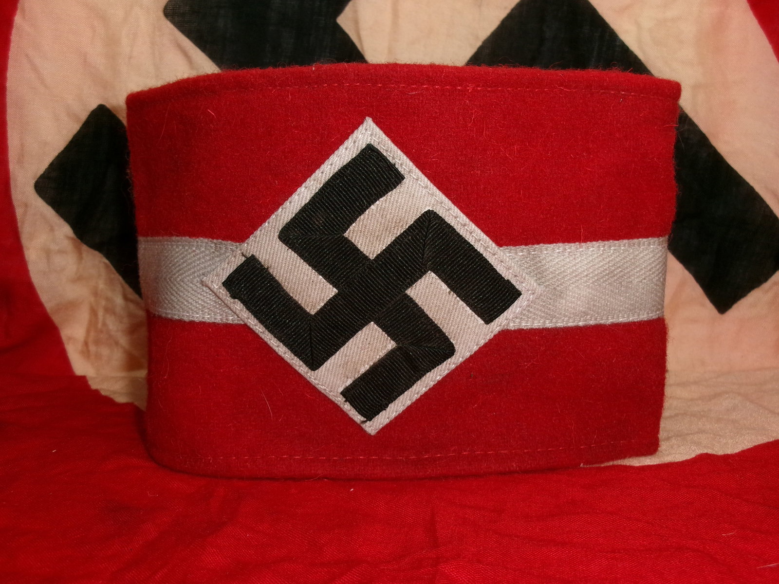 WW2 German Hitler Youth Armband with RZM Tag: WW2 German Hitler Youth (Hitlerjugend) armband, featuring the classic red field with a white central band and applied diamond-shaped patch bearing a black swastika. This style of armband was worn by m