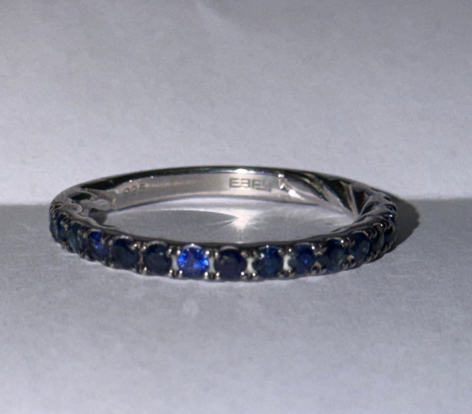 Effy Half Eternity Sapphires Band Ring Sz 6: Elegant Effy band ring crafted in sterling silver, featuring a row of deep blue round-cut stones set across the front in a classic half eternity style. The rich color of the stones contrasts beautiful