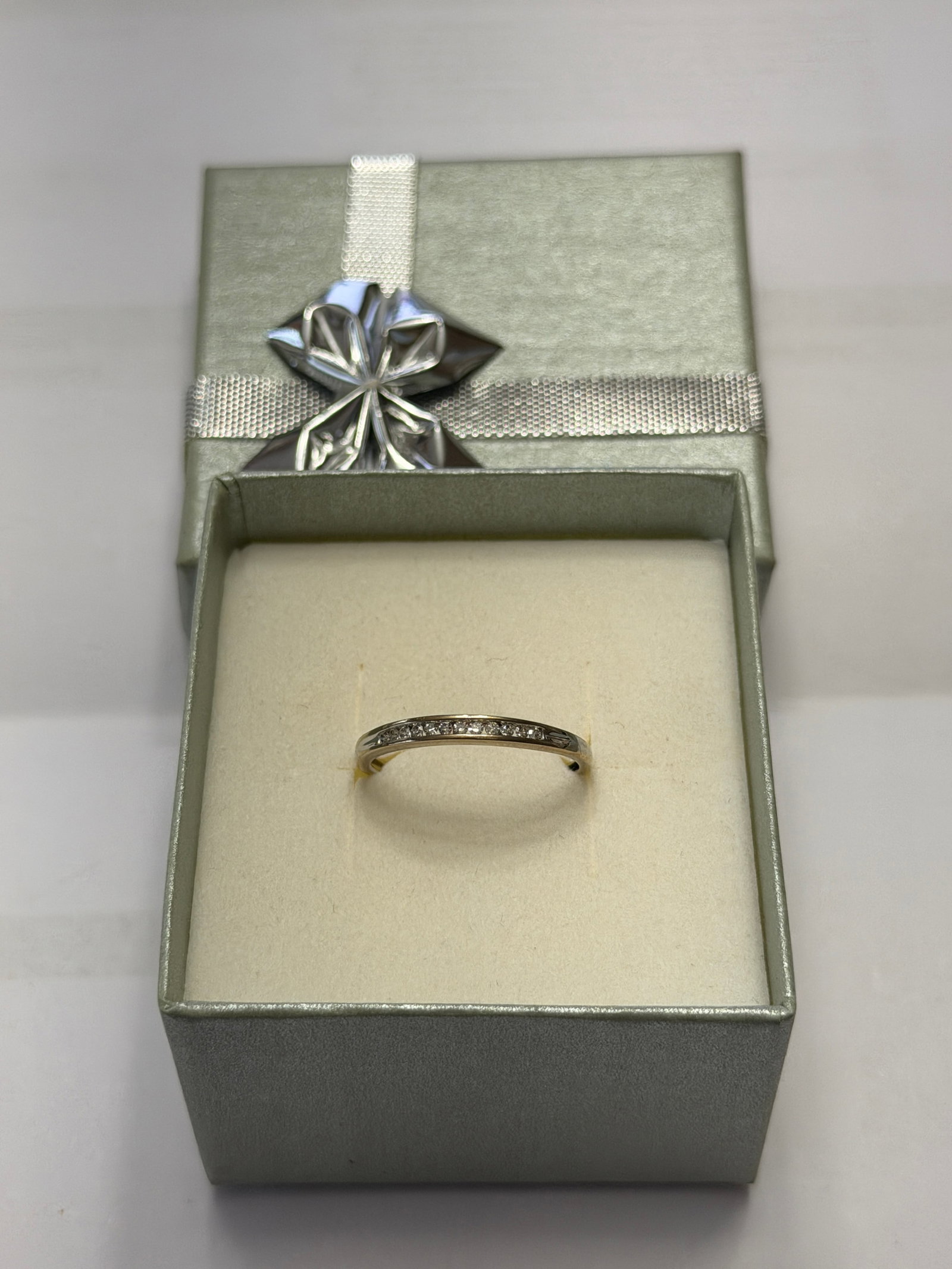 Exquisite 10KWhite Gold Ladies Diamond Band Sz 6.5: Elegant and timeless, this delicate ladies band is crafted in 10K white gold and features a row of sparkling accent diamonds set into a sleek, slightly curved channel across the top. The minimalist de