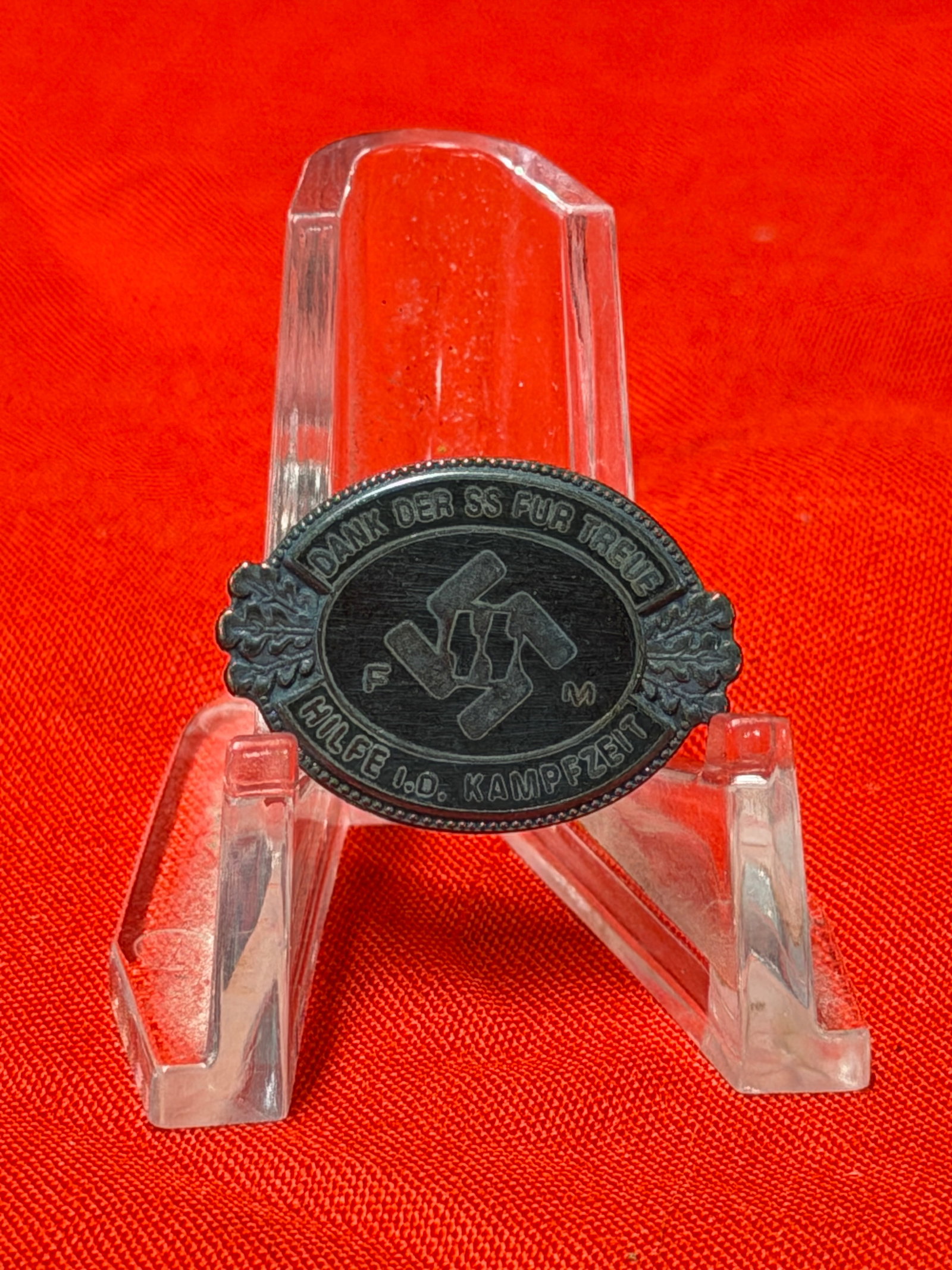 WWII German SS FM Loyalty Enameled Badge / Tinnie Pin Marked RZM M1/133: WWII German SS-style commemorative loyalty badge featuring black enamel-style center with SS runes and German inscription reading “Dank Der SS Für Treue Hilfe I.D. Kampfzeit.” Oval form with 
