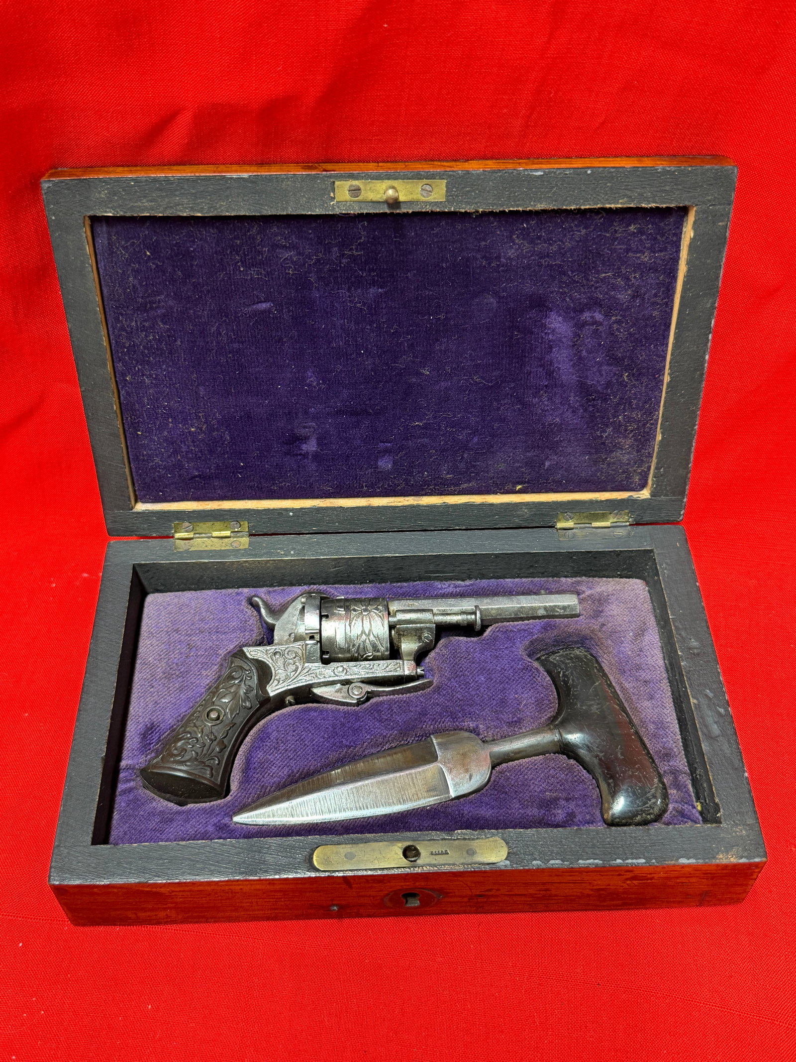 Civil War Era Style Miniature Revolver & Push Dagger Set with Wooden Display Box: Civil War era style miniature revolver and push dagger set displayed in a fitted wooden presentation box with purple velvet-style lining. In our opinion, this is a striking historical-style collectibl