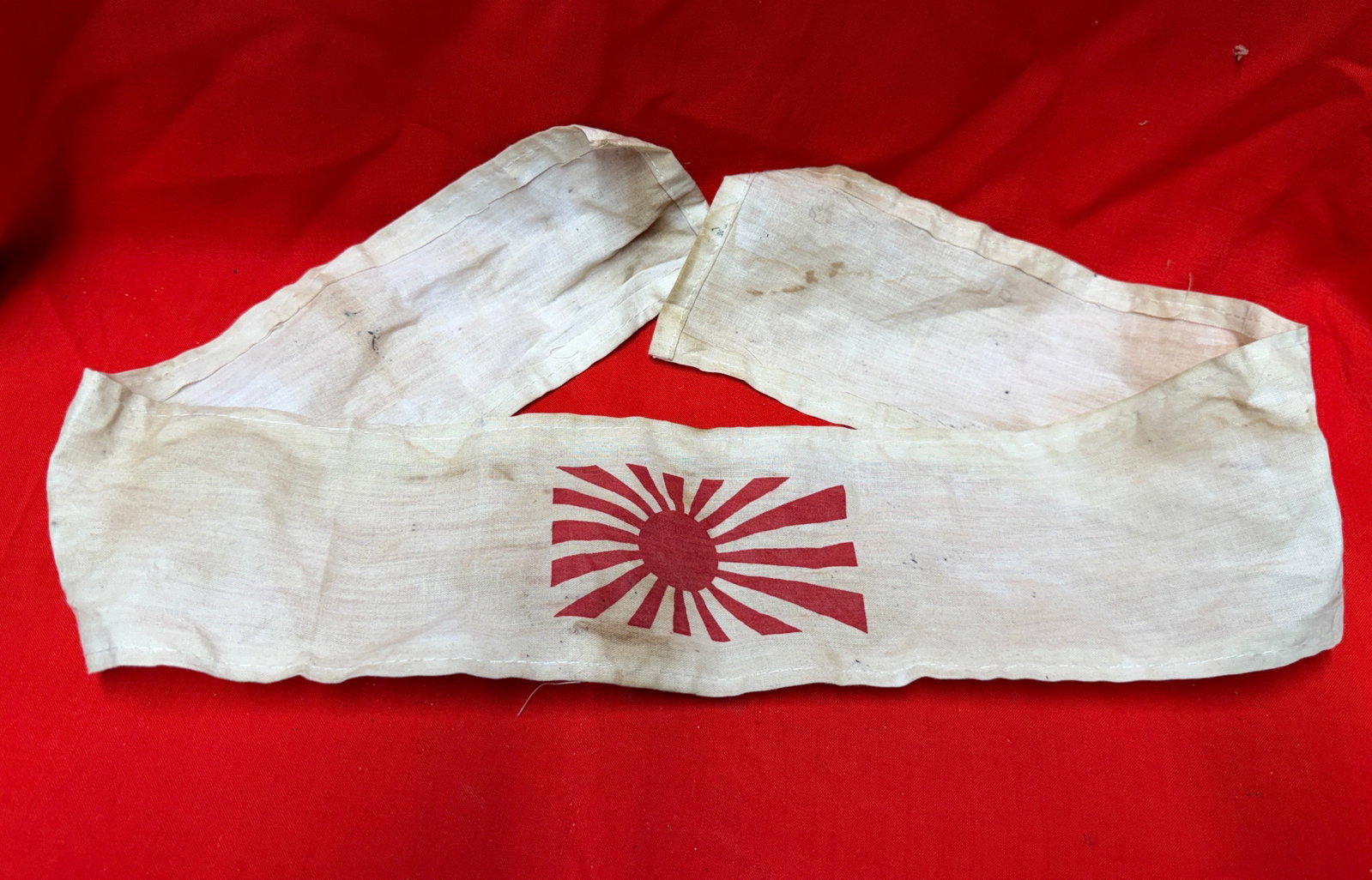WW2 Japanese Rising Sun Kamikaze Style Headband Cloth Hachimaki: WW2 Japanese kamikaze style cloth hachimaki headband featuring the Rising Sun design printed in red on lightweight fabric. In our opinion, this is a compelling historical military collectible with cla