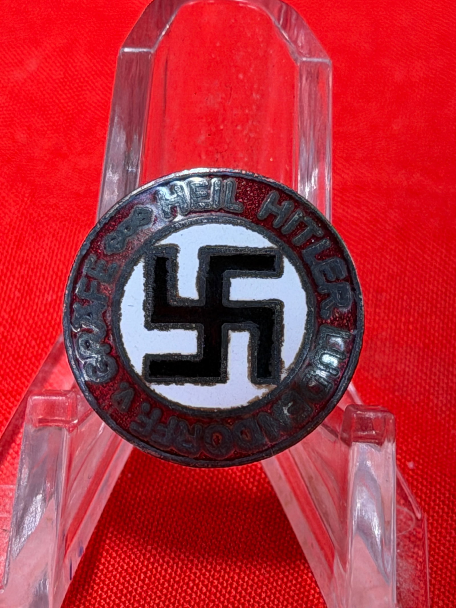 WWII German NSDAP “Heil Hitler?? Enamel Party Pin Badge – M1/73 Marked Political Lapel Badge: WWII-era German NSDAP-style political lapel badge featuring the iconic black swastika centered on a white enamel field with a red outer ring and raised silver-tone lettering. The circular border reads