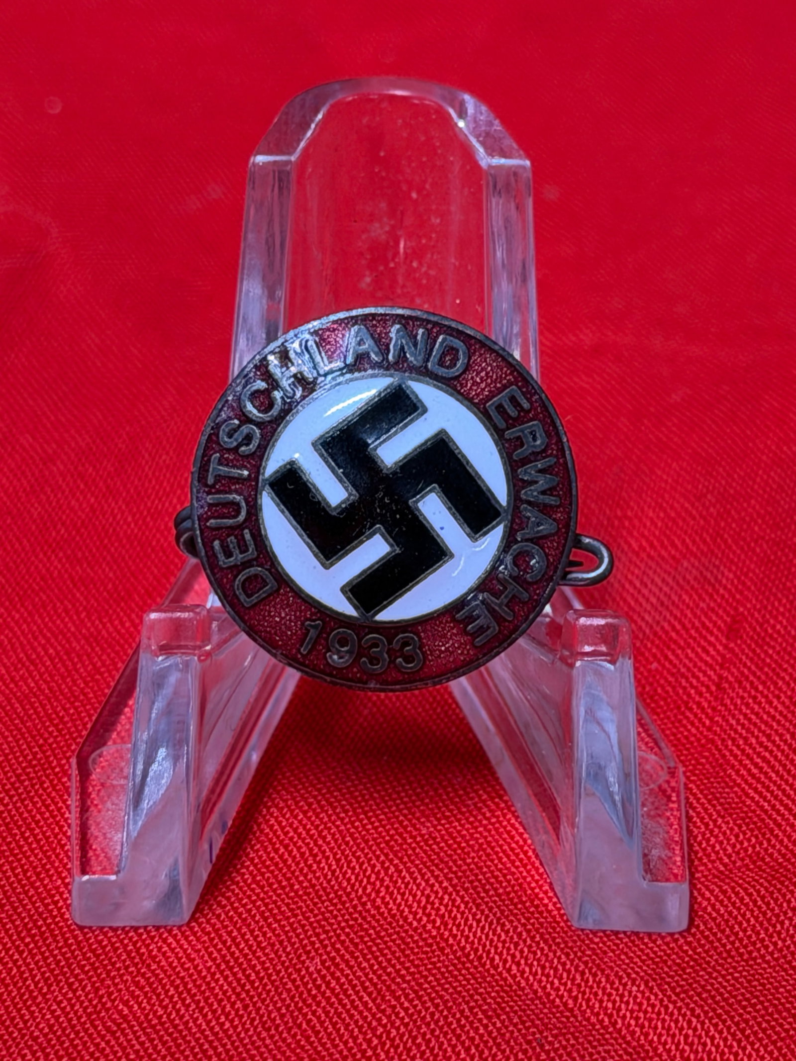 1933 Deutschland Erwache Political Pin Badge WWII Era German Memorabilia: Vintage round pin badge featuring the text “Deutschland Erwache 1933” surrounding a central black swastika emblem on a white background with red enamel-style outer ring. This piece displays cl