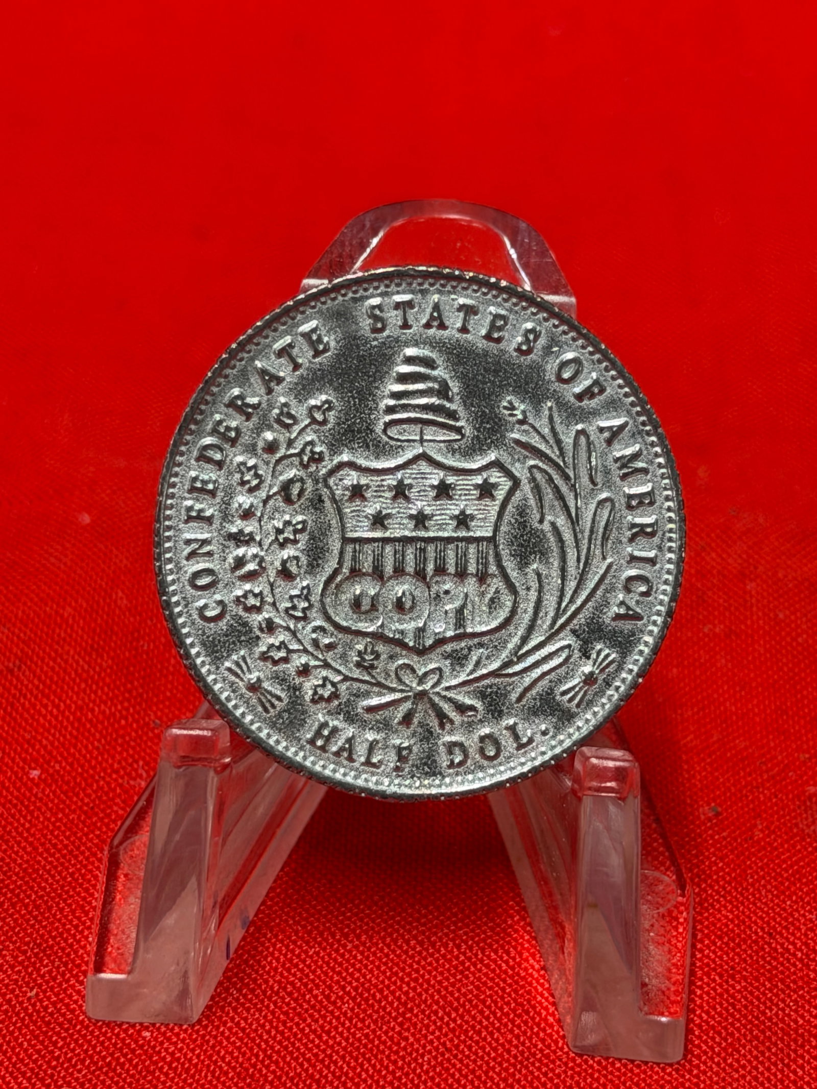 1861 Confederate States of America Half Dollar Style Collectible Coin: This collectible coin features the Confederate States of America half dollar style design with shield, wreath, liberty seated figure, and 1861 date details visible on both sides. In our opinion, this 