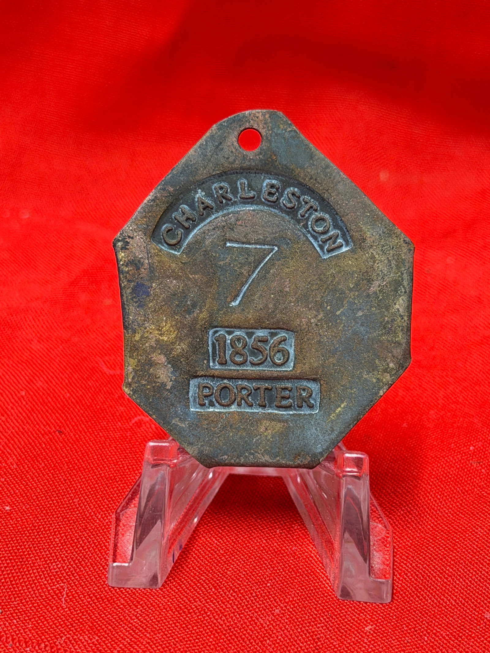Antique 1856 Charleston Porter Slave Tag Number 7 Historical Relic: Antique metal slave tag marked “Charleston 7 1856 Porter.” Features octagonal form with punched suspension hole at top and deeply stamped lettering. In our opinion this piece appears consisten