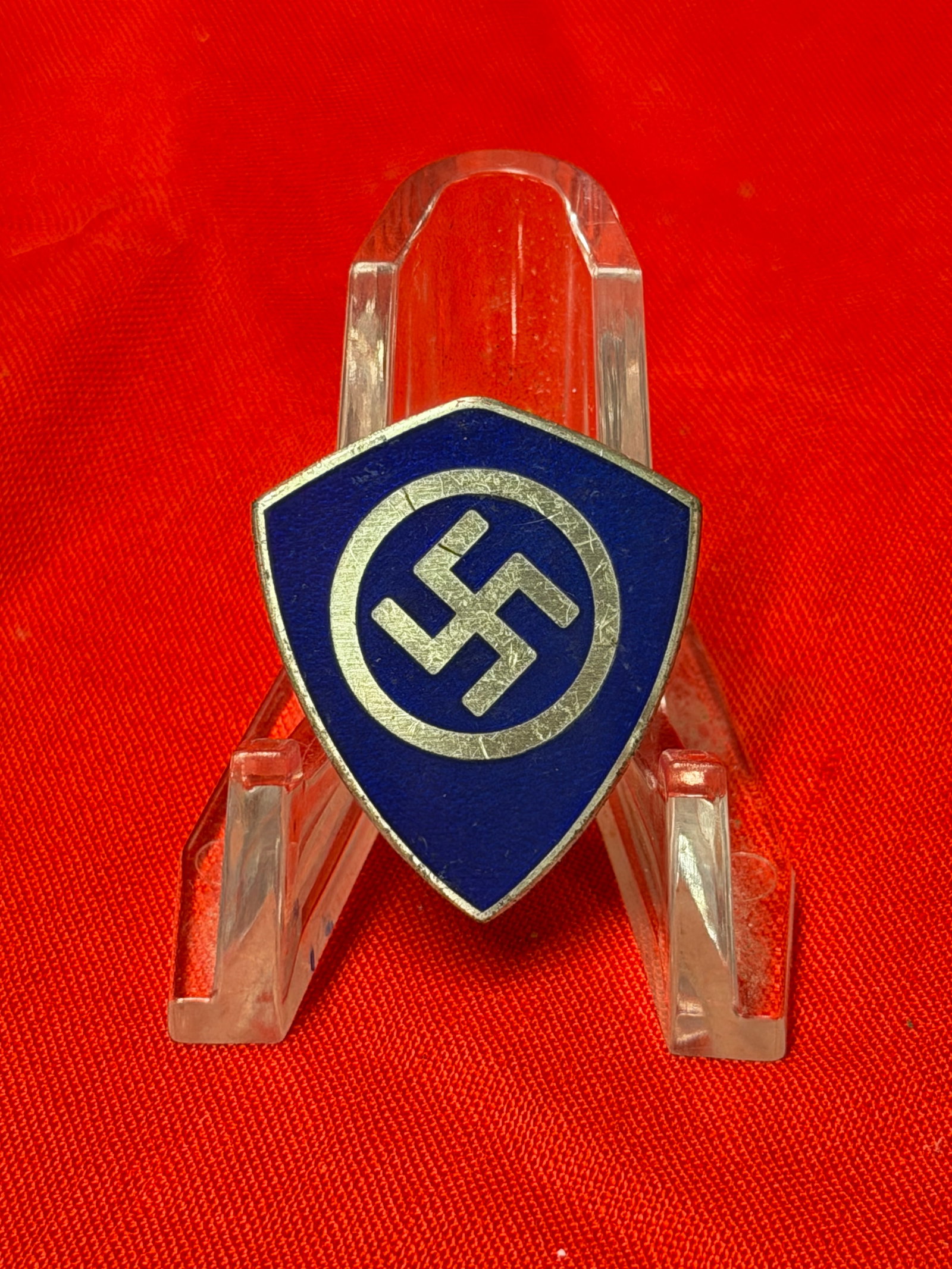 WW2 German Style Blue Shield Lapel Pin Badge Marked Ges. Gesch.: German style blue enamel shield pin featuring a silver tone circular emblem design with Ges. Gesch. marking on the reverse. In our opinion this piece appears to be a period style organizational or com