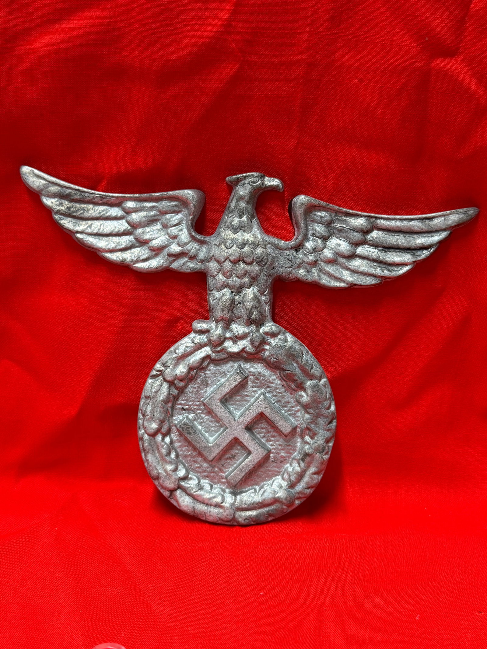 WW2 German Style SA Eagle Wall Plaque Cast Metal Display Piece: WW2 German style cast metal eagle wall plaque featuring a spread wing eagle above a wreath and central emblem design. In our opinion this piece appears to be a period style military themed decorative 