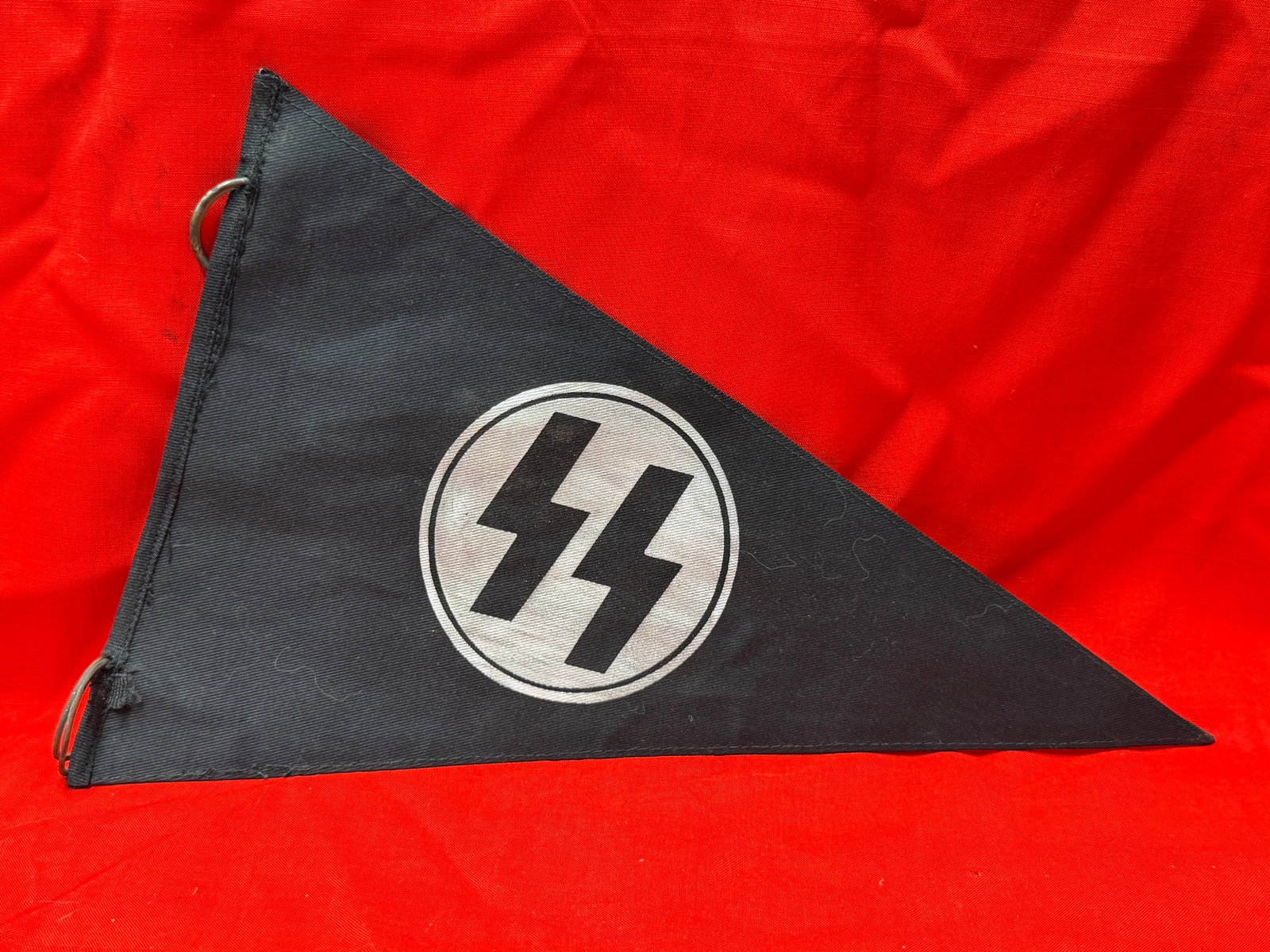 WW2 German SS Style Black Triangular Pennant Banner With Double Bolt Emblem: German SS style black triangular pennant banner featuring the double bolt emblem within a white circle printed on black fabric. The pennant is constructed with stitched edges and metal hanging rings a