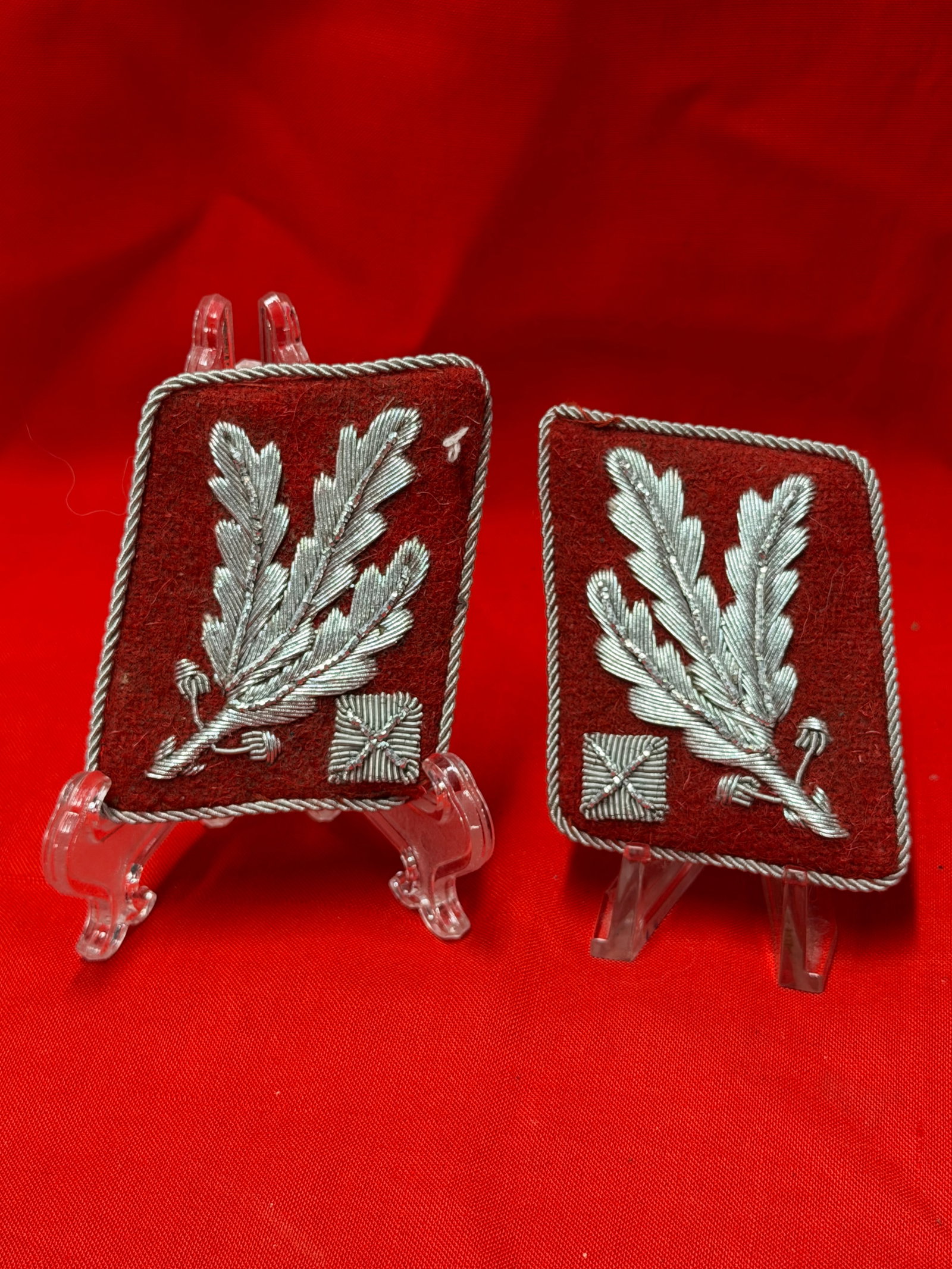 WW2 Waffen SS Division Red Collar Tab Pair Silver Bullion Style Insignia: Pair of WW2 Waffen SS division style red collar tabs featuring silver bullion style oakleaf embroidery with twisted silver edge trim backing. Includes matching pair as shown with detailed wire style e