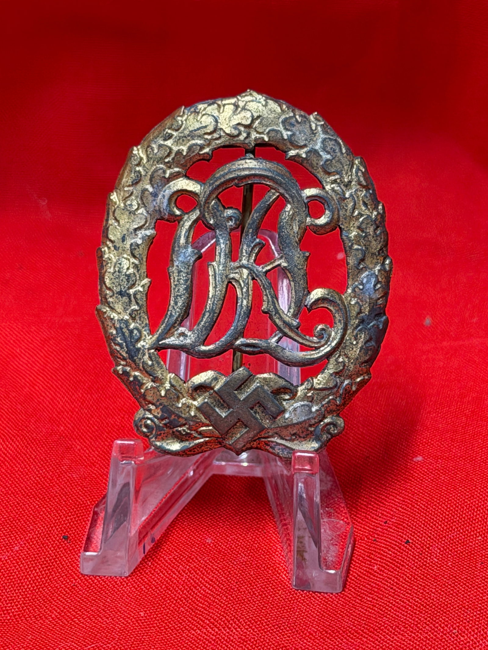 WW2 German DRL Sports Badge Bronze Tone Pinback Insignia: WW2 German DRL style sports badge featuring open wreath design with central DRL lettering and bronze tone finish. Pinback construction on reverse with detailed raised design throughout. In our opinion