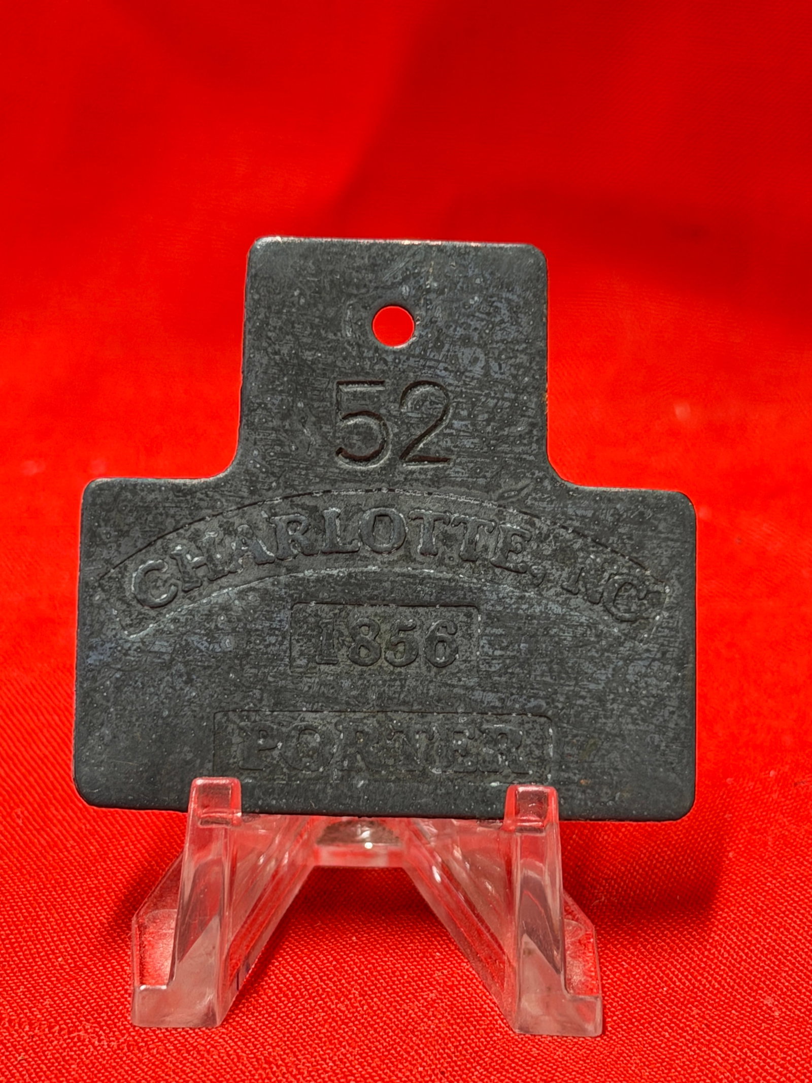 Charlotte NC 1856 Porter Slave Tag Badge No. 52: Rare Charlotte NC occupational slave tag badge marked “CHARLOTTE NC,” “1856,” “PORTER,” and numbered “52.” Dark aged metal construction with strong embossed lettering a