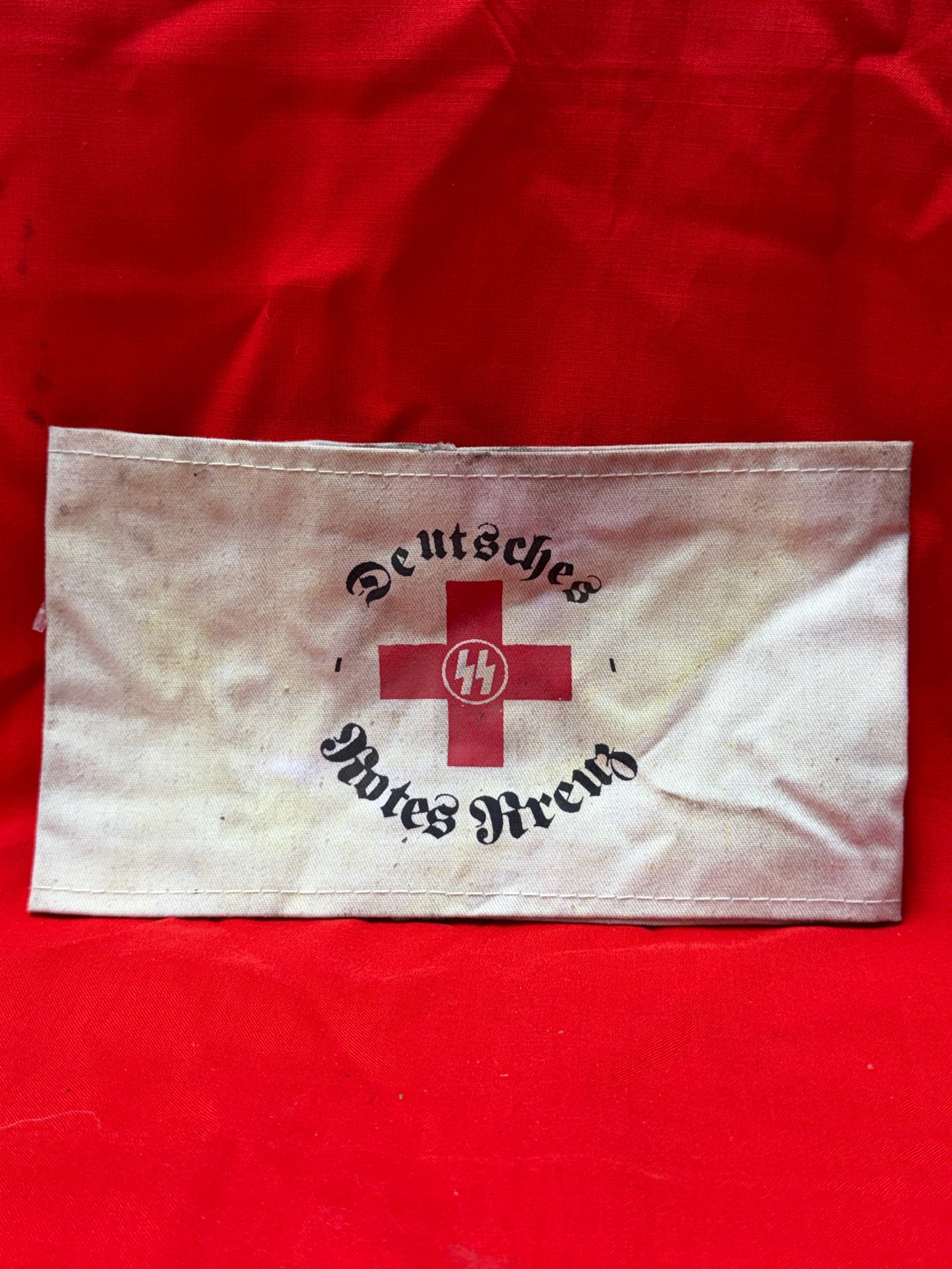 WW2 German SS Deutsches Rotes Kreuz (DRK) Nurse / Medical Armband – RZM Tagged: WW2 German Deutsches Rotes Kreuz (DRK) medical armband featuring SS runes within a red cross roundel and gothic “Deutsches Rotes Kreuz” script across the front. In our opinion, this appears to
