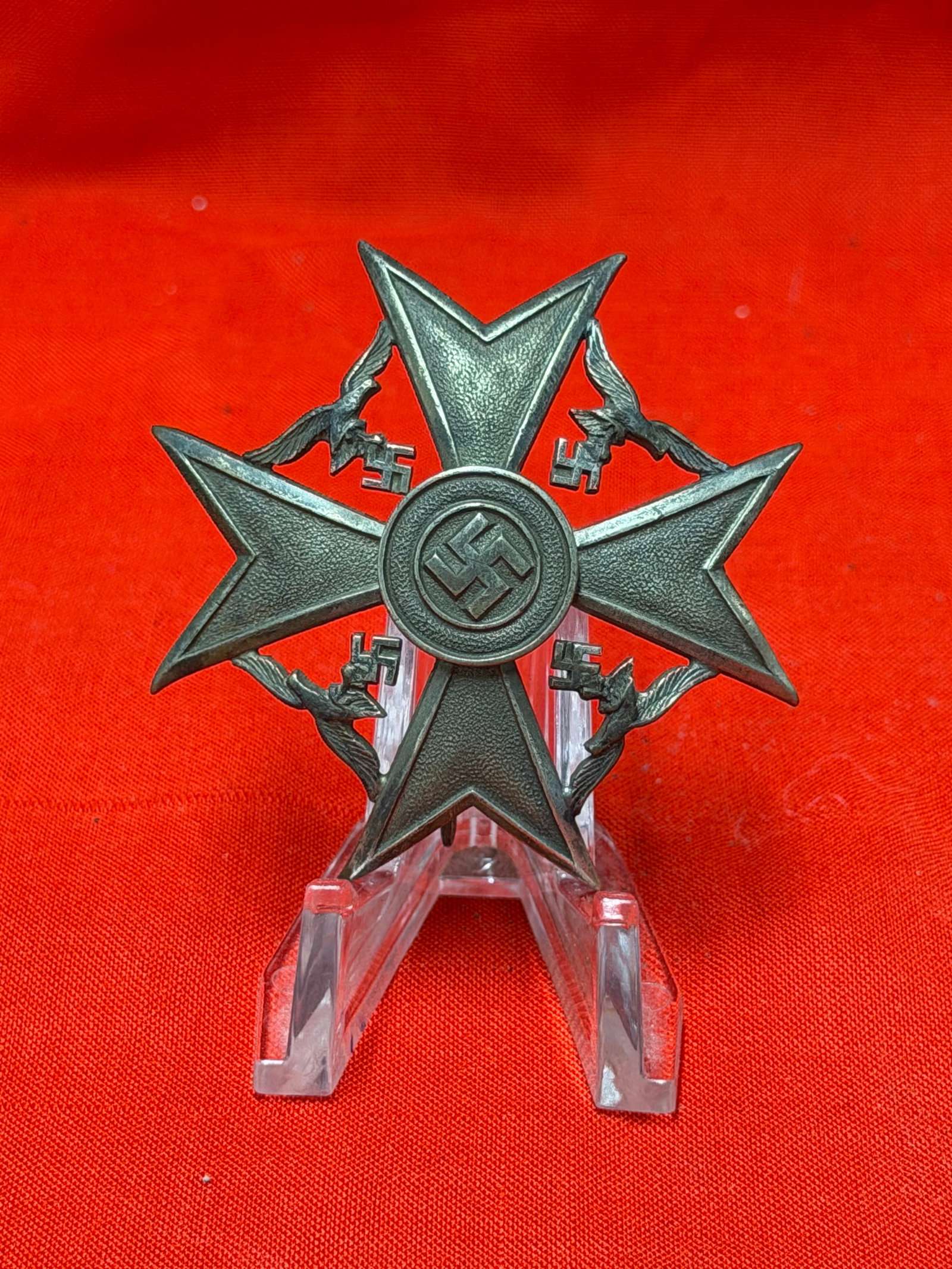 WWII German Spanienkreuz Spanish Cross Badge: WWII German Spanienkreuz (Spanish Cross) badge featuring the distinctive multi-point cross design with central emblem and wreath details. Constructed of darkened metal with an attached vertical pinbac