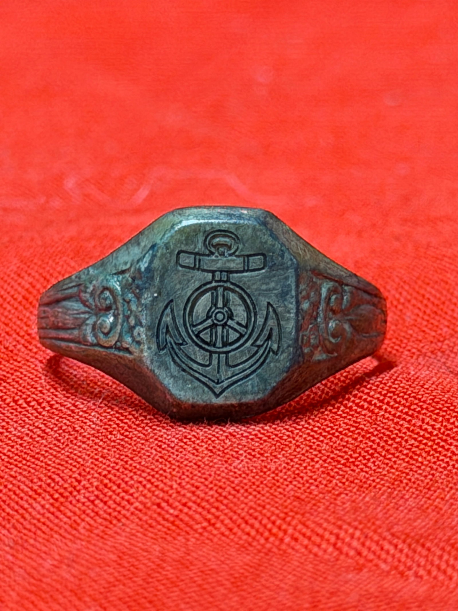 WWII German U-Boat Officer Ring Kriegsmarine Naval: WWII German U-Boat officer ring featuring an engraved anchor and naval wheel emblem on the face with decorative side detailing along the shank. In our opinion this piece represents a German Kriegsmari