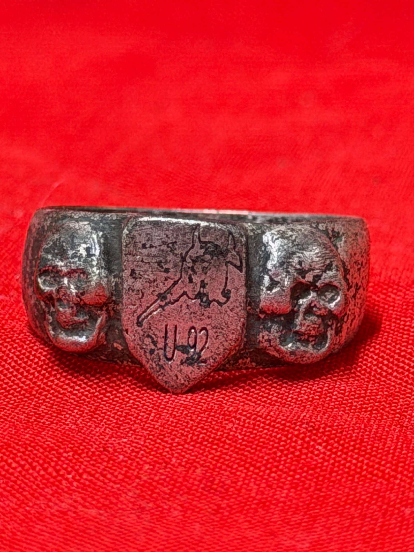 WWII German Totenkopf U-92 Uboat Navy Soldier's Skull Ring: WWII German Totenkopf ring featuring dual skull motifs and central shield marked “U-92” with engraved insignia detail. In our opinion this piece represents a German naval themed wartime era co