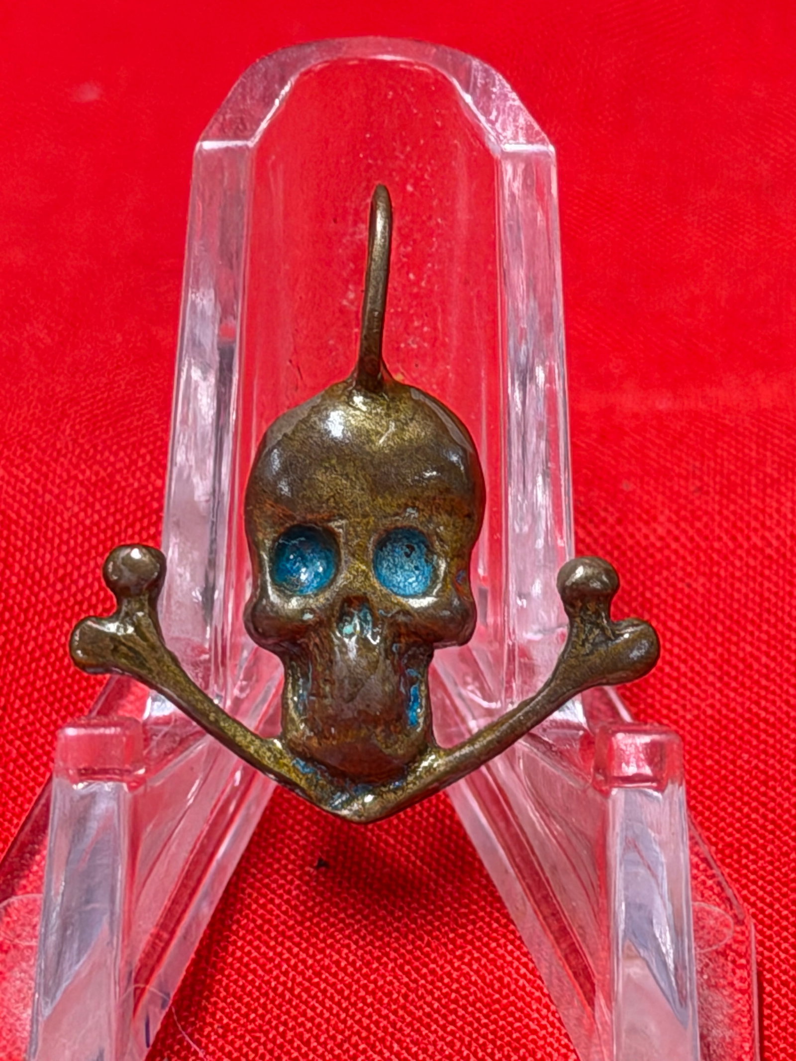 WWII German Totenkopf Skull & Crossbones Pendant: WWII German Totenkopf style skull and crossbones pendant featuring blue enamel-style eye accents and integrated suspension loop. In our opinion this piece represents a wartime era military-themed coll
