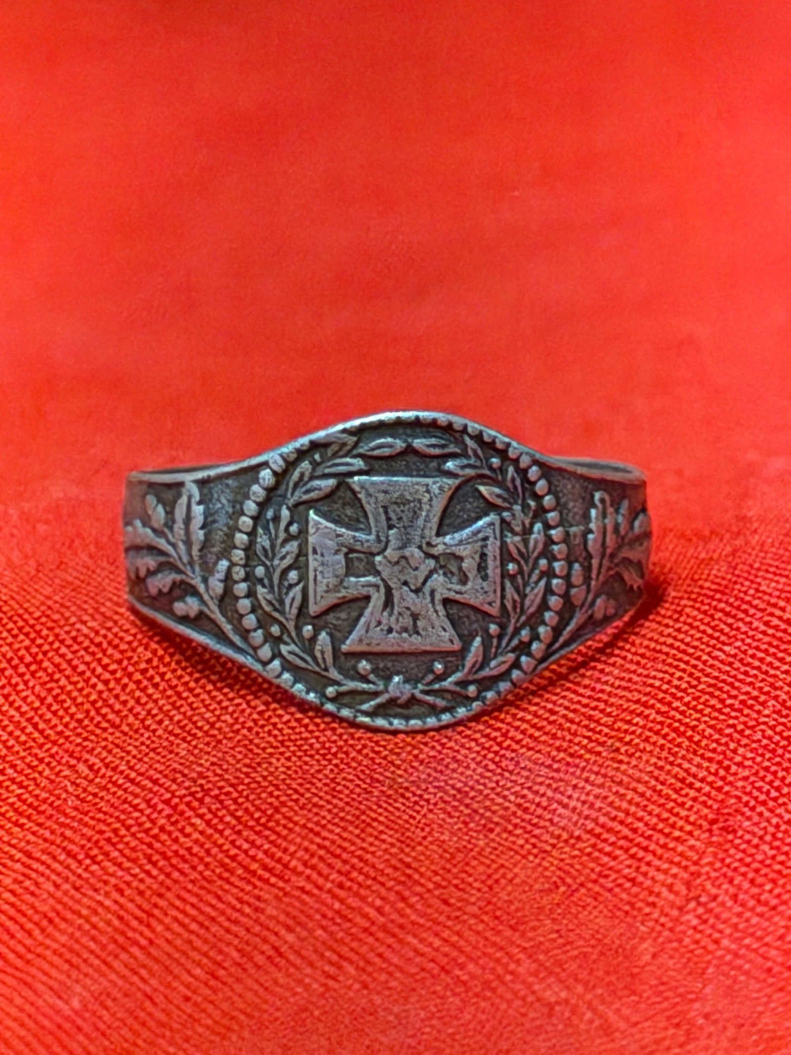 WWII German Iron Cross Patriotic Ring – Marked “GES. GESCH.: WWII era German patriotic style ring featuring a raised Iron Cross motif surrounded by laurel wreath detailing and oak leaf accents along the shoulders. Interior is marked “GES. GESCH.” indica