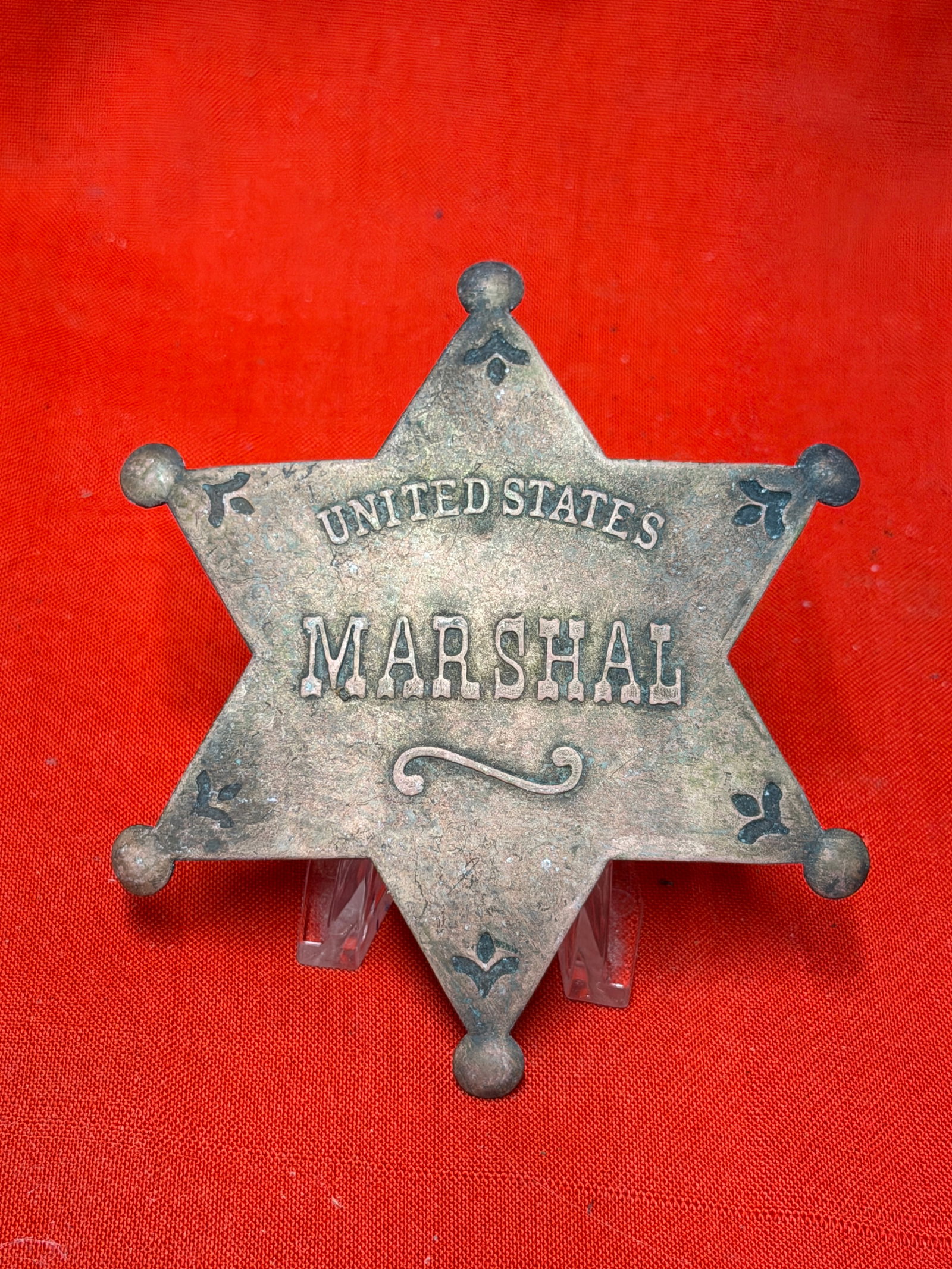 Antique United States Marshal Six-Point Star Badge: United States Marshal six-point star badge constructed in the classic Old West style with raised lettering and decorative black enamel accents at each point. Features the iconic frontier-era lawman de