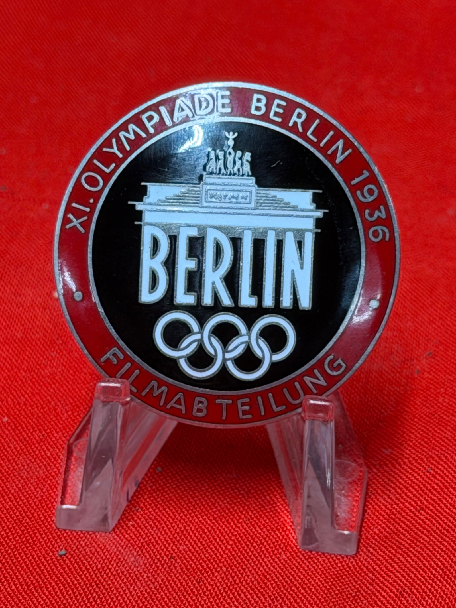 WW2 1936 Berlin Olympics “Filmabteilung?? German Pin Badge by Rob. Neff Berlin: 1936 Berlin Olympics “Filmabteilung” (Film Department) commemorative pin badge featuring Berlin Olympic branding, Olympic rings, and Brandenburg Gate design in black, red, and silver enamel. F