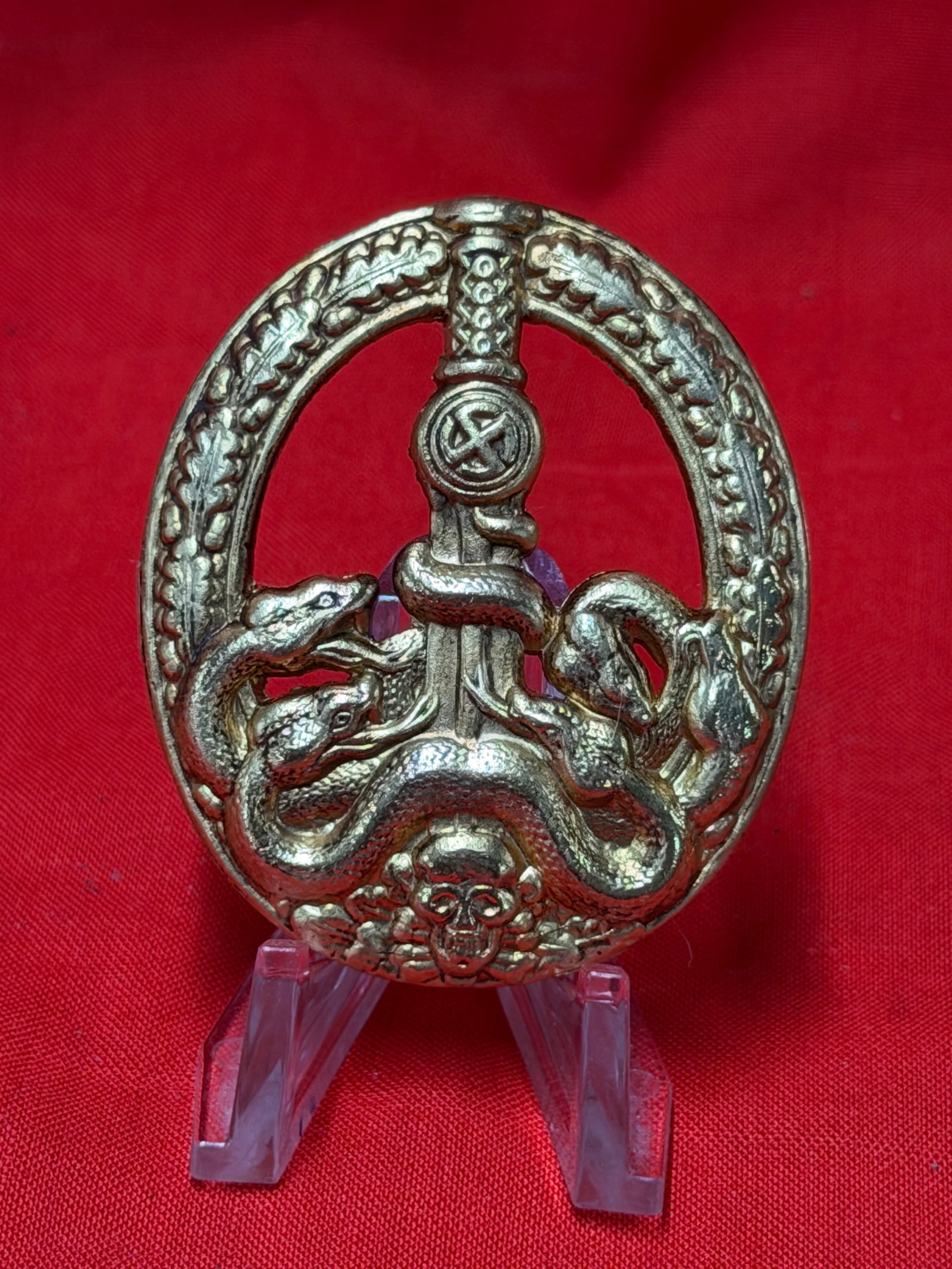 WW2 German SS Anti Partisan Badge Snake & Sword Design Pinback Badge: In our opinion this WW2 German SS anti partisan related badge features the well known snake wrapped sword and skull motif within an oakleaf wreath design. Reverse retains vertical pinback assembly. Ba